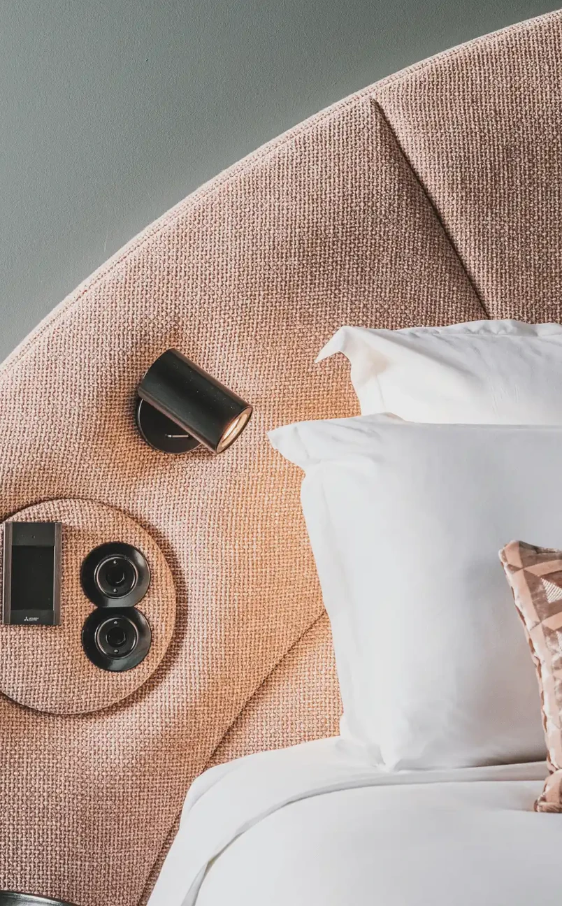 Detail of interior design, textured headboard and modern reading lamp in an Experimental Group hotel room.