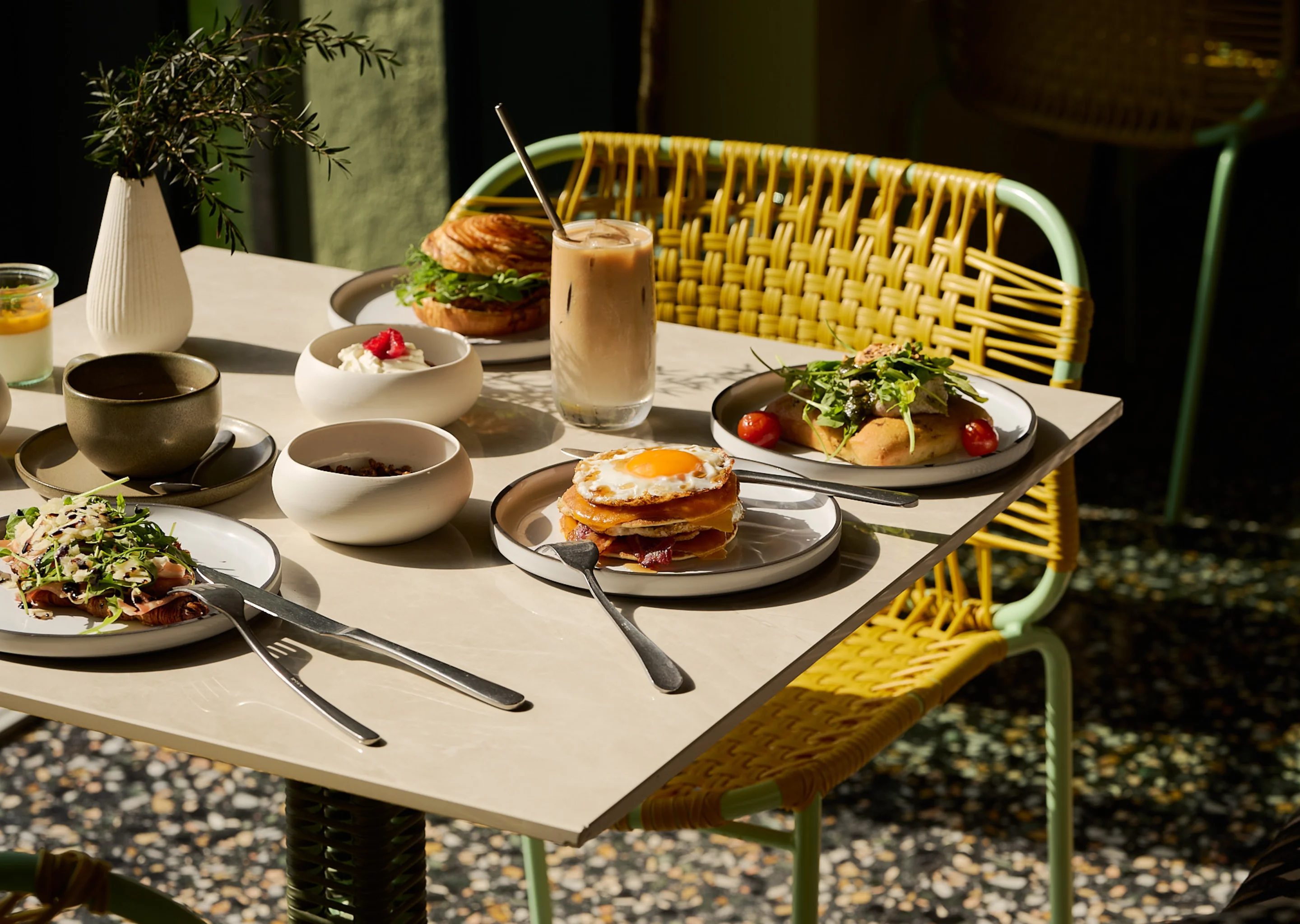Elegant breakfast spread on a sunny terrace at Hôtel Régina Experimental, Biarritz, with various dishes and drinks.