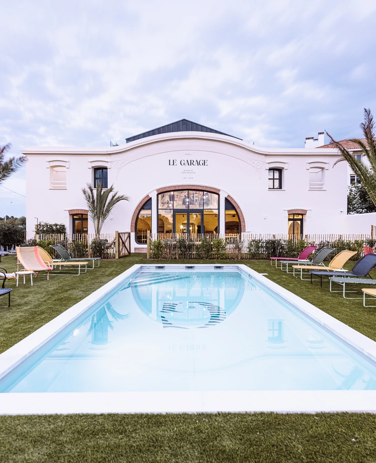 Unique architecture and exterior of the Le Garage hotel in Biarritz under a twilight sky.