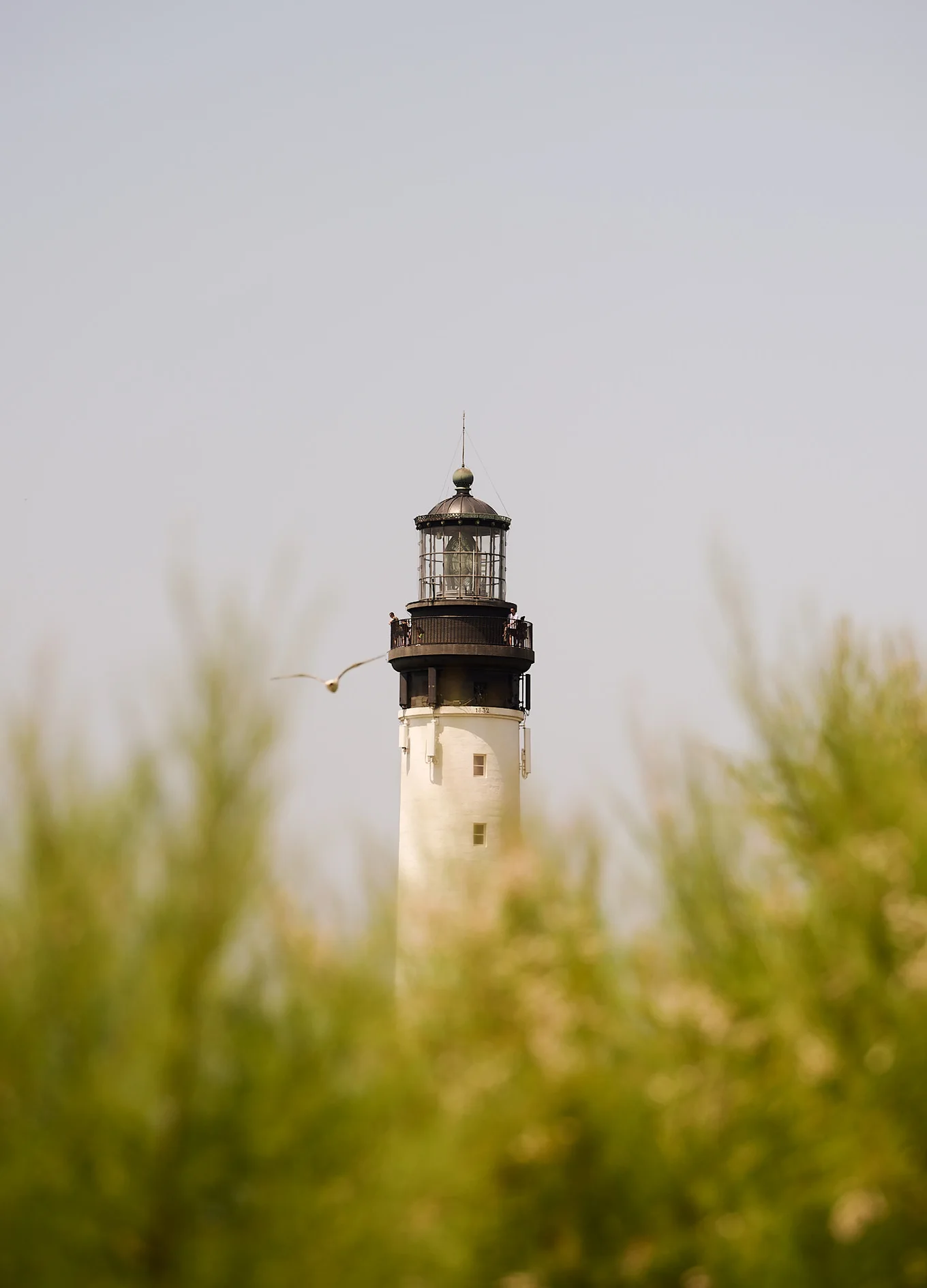 Close-up view of the Biarritz Lighthouse near the Le Garage hotel, under a clear sky.