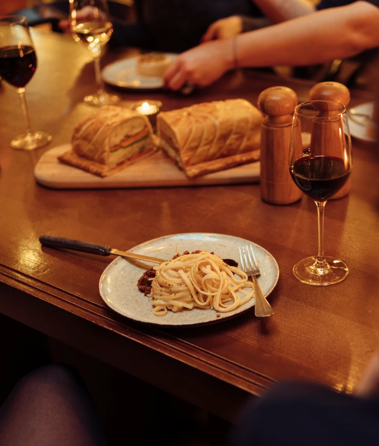 Close-up of a pasta dish and a glass of wine on a restaurant table, Experimental Group.