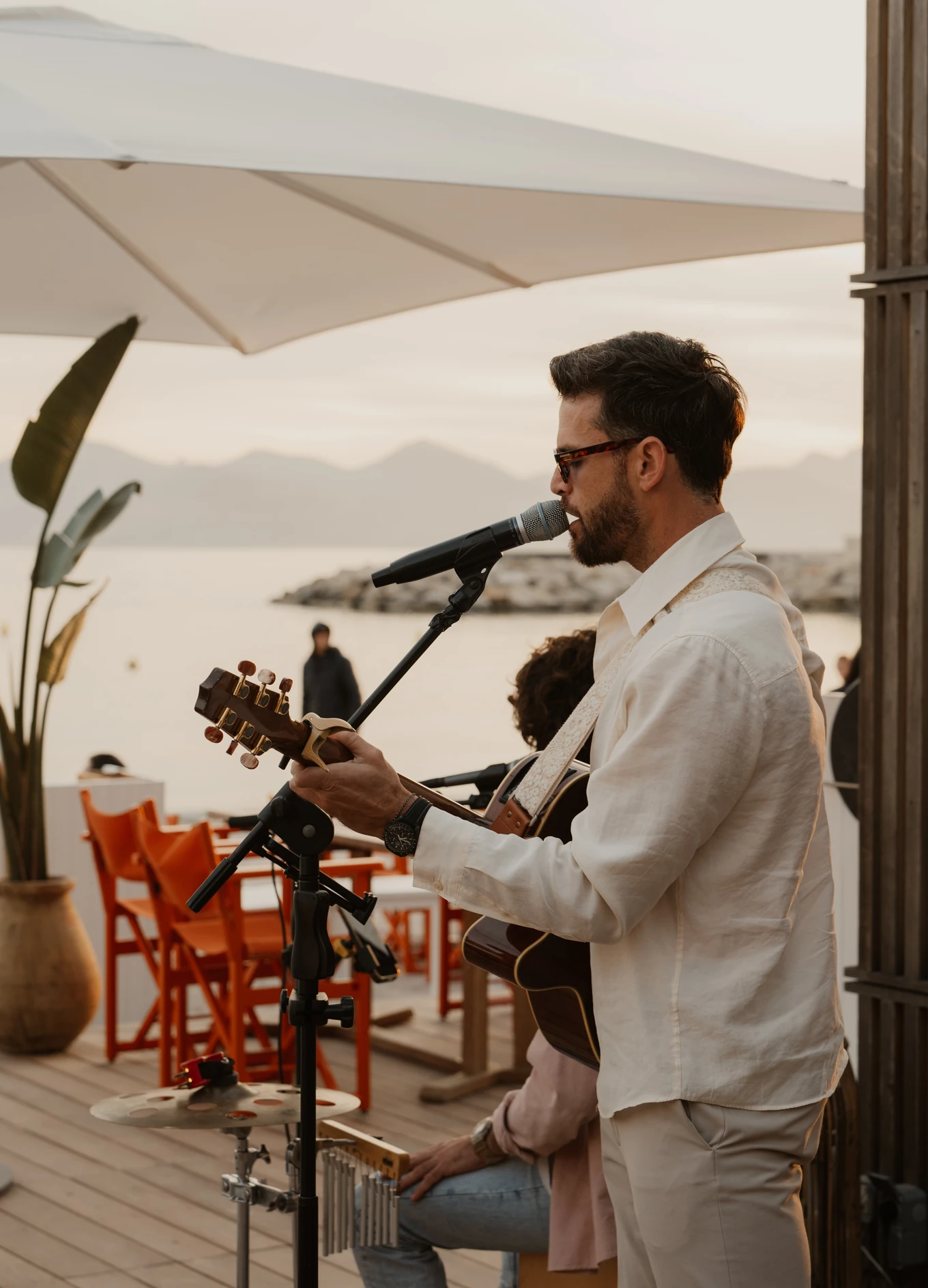Musician playing guitar during a live session at Experimental Group by the sea.