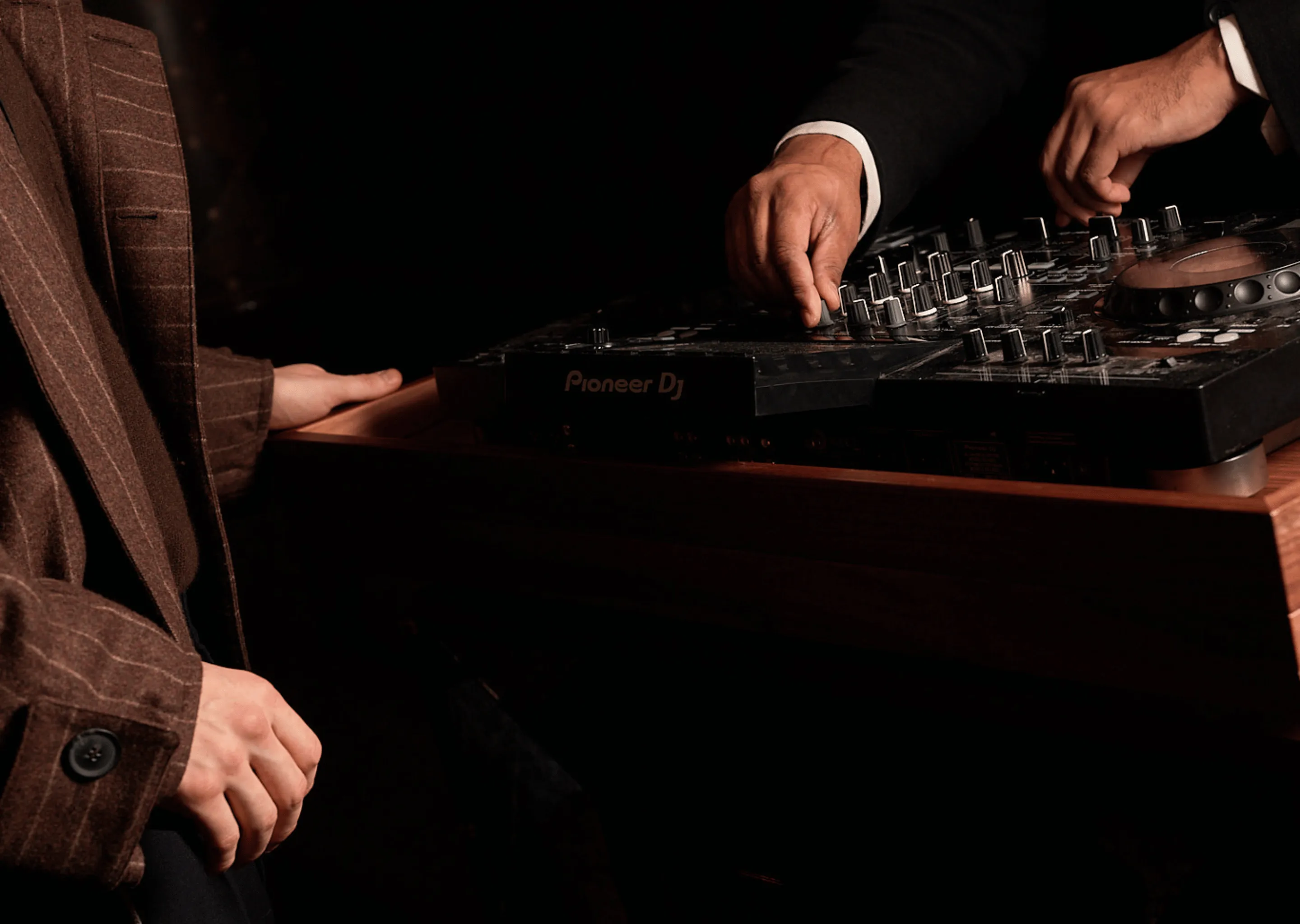 DJ mixing on a Pioneer console during a private event at an Experimental Group hotel, elegant and immersive atmosphere.