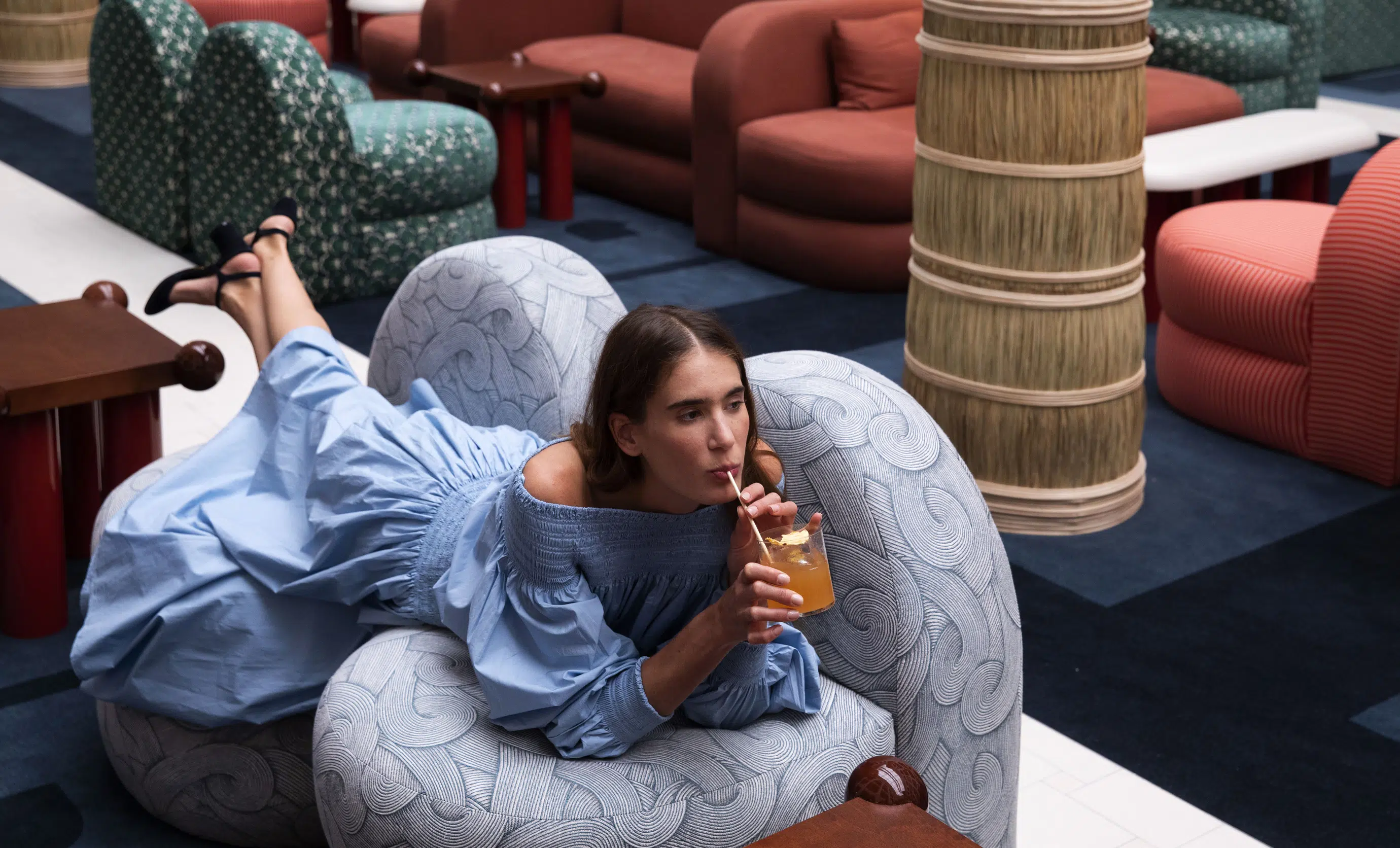 Guest relaxing in a modern, stylish lounge with patterned armchair at an Experimental Group hotel.