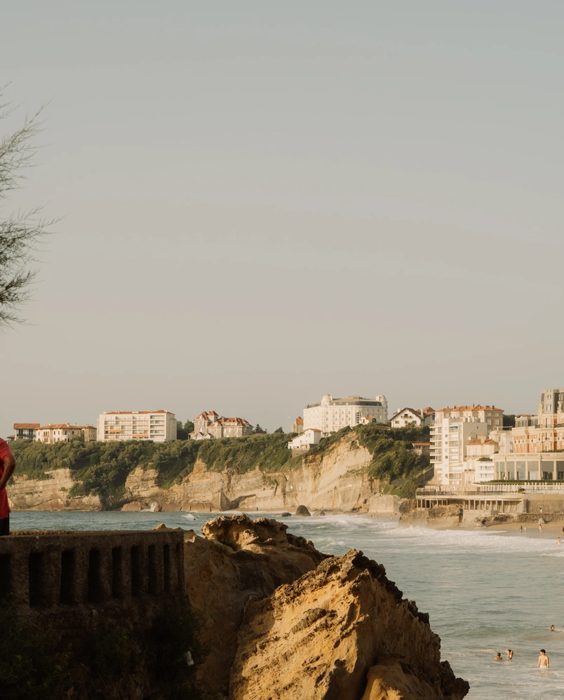 Scenic view of the rugged coastline and the Regina Experimental hotel in Biarritz, showcasing its unique architecture and seaside location.
