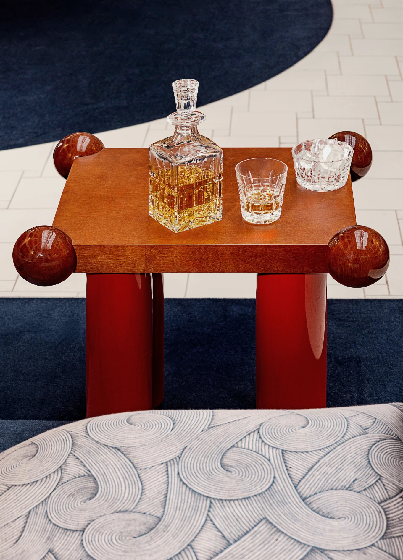 Detail of a designer coffee table with a decanter and glasses in the chic lobby of the Regina Experimental.