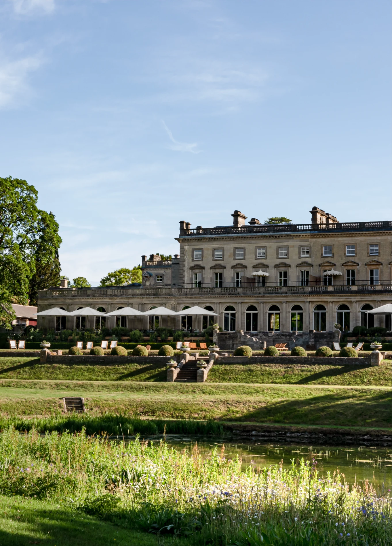 Façade extérieure du Cowley Manor avec grandes pelouses vertes, hôtel spa de luxe, Cotswolds