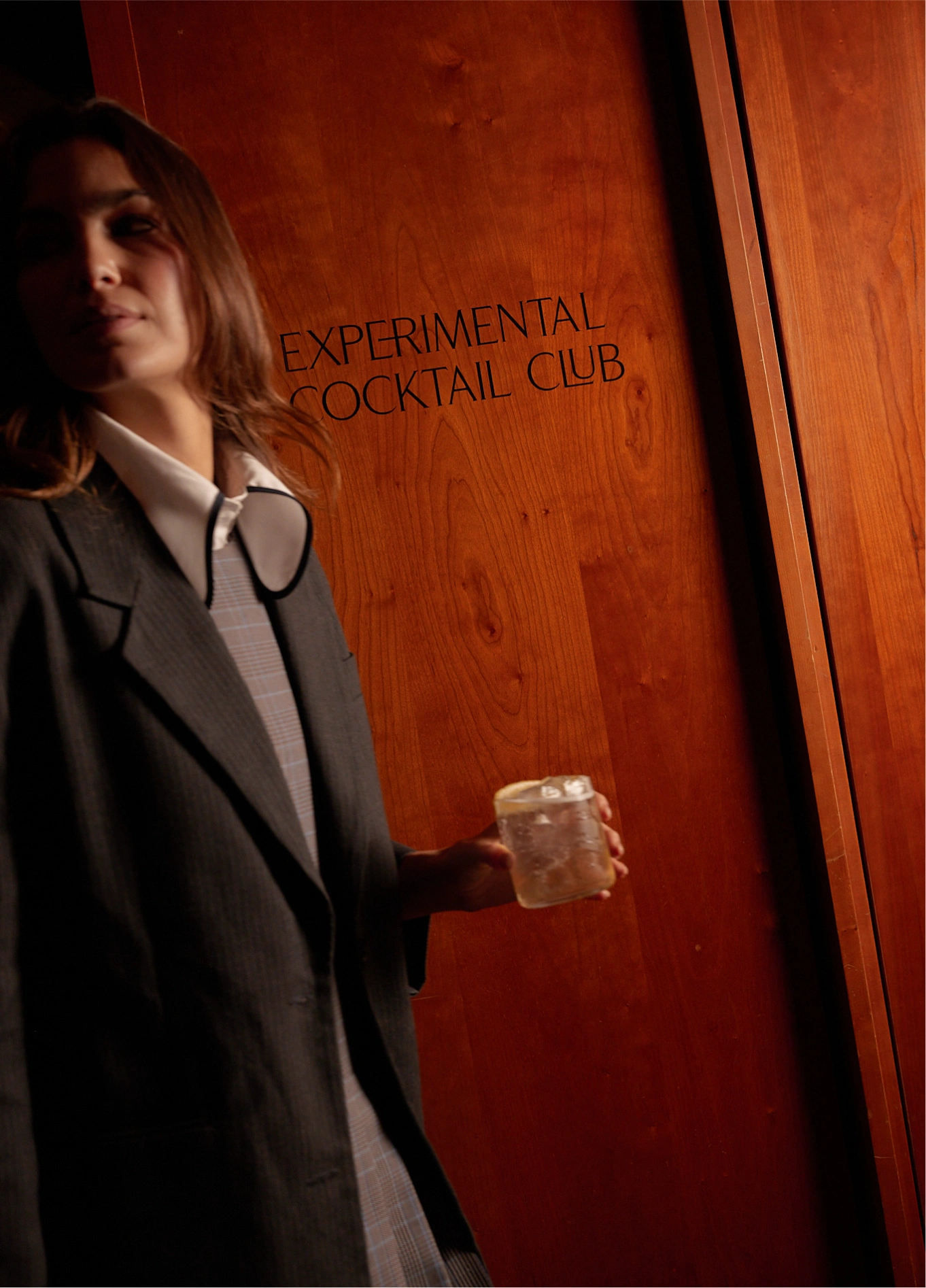 Woman entering the red door of Experimental Cocktail Club, Cotswolds
