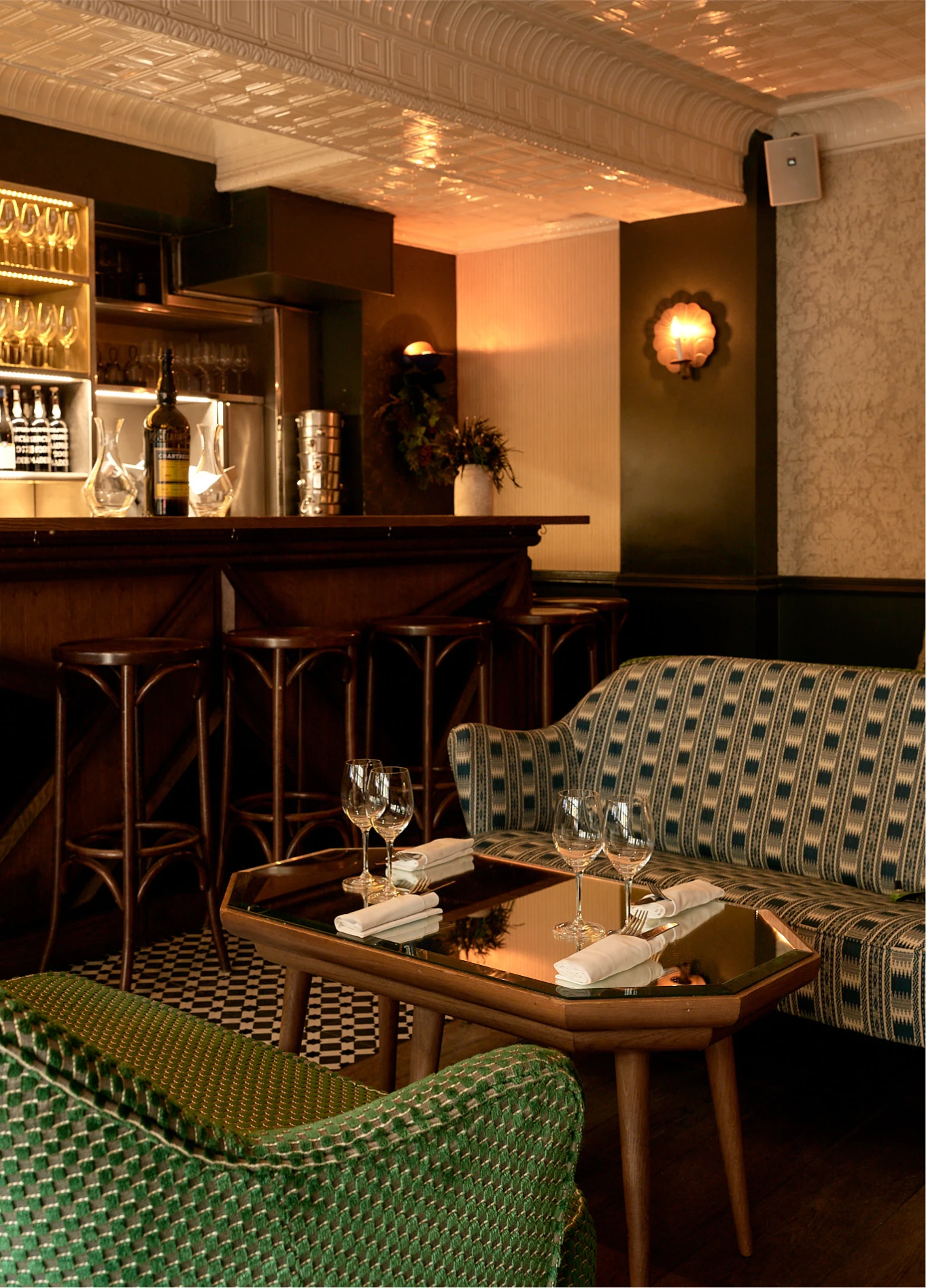 Warm interior of La Compagnie Wine Bar featuring a bar counter, high stools, and a cozy lounge area with sofas.
