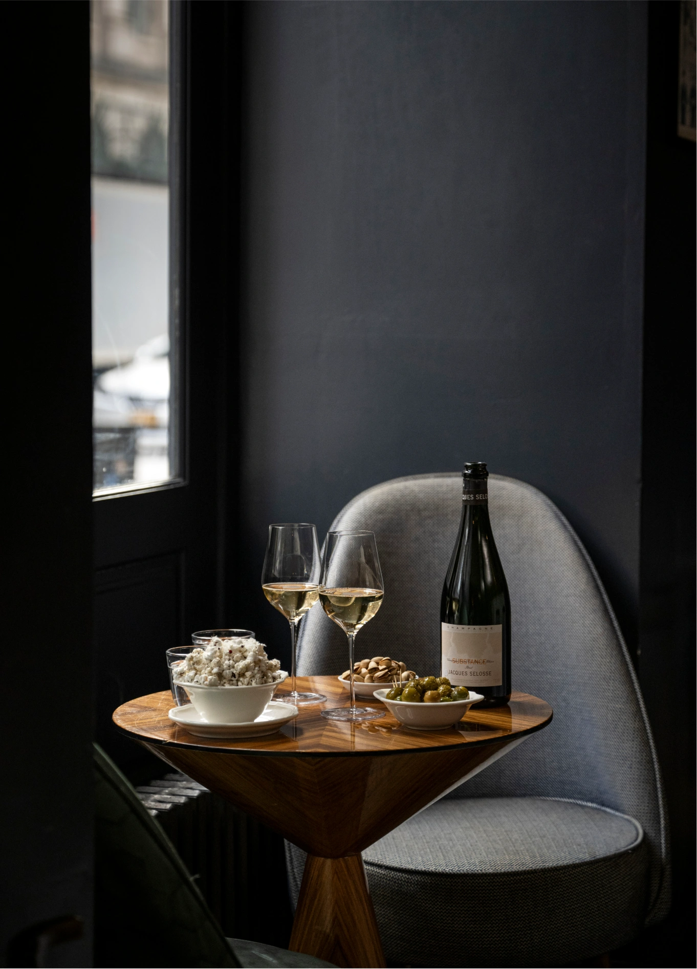 Intimate table setup with a wine bottle and glasses in the lounge area of La Compagnie Wine Bar.
