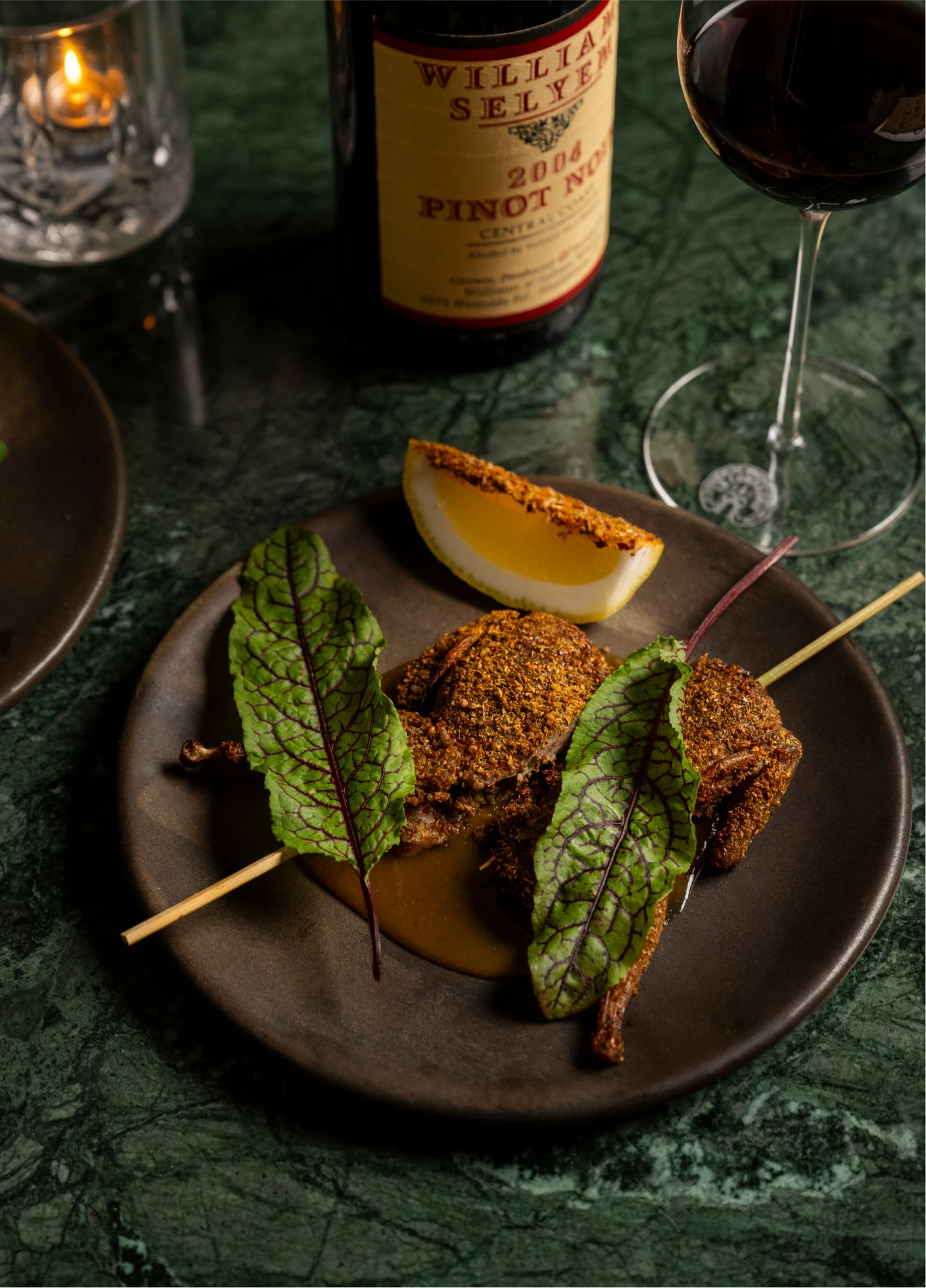 Gourmet appetizer served on a skewer with a touch of greens, accompanied by wine at La Compagnie Wine Bar.
