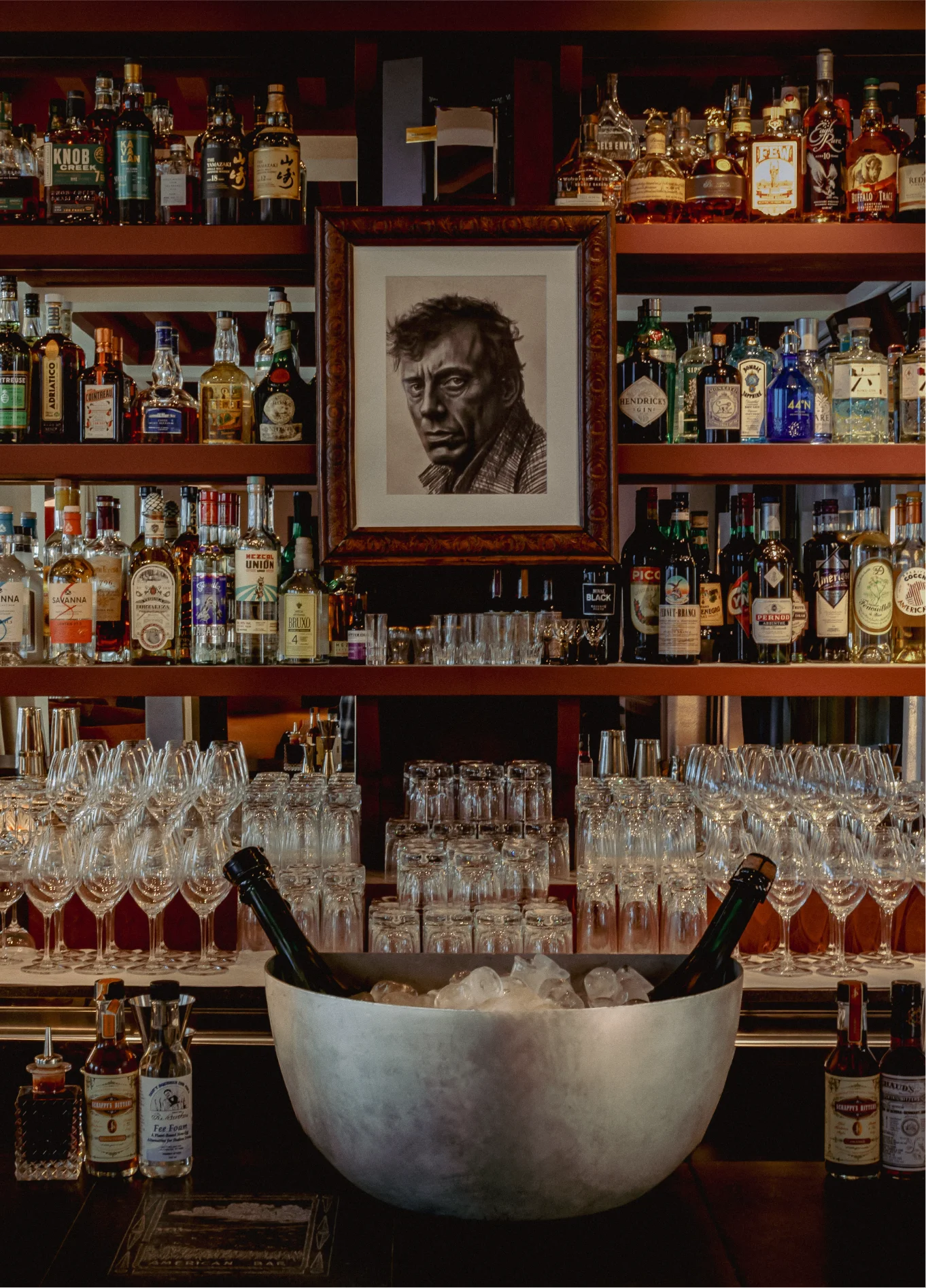 Wall of bottles with portrait and ice bucket at American Bar, Il Palazzo, Venice