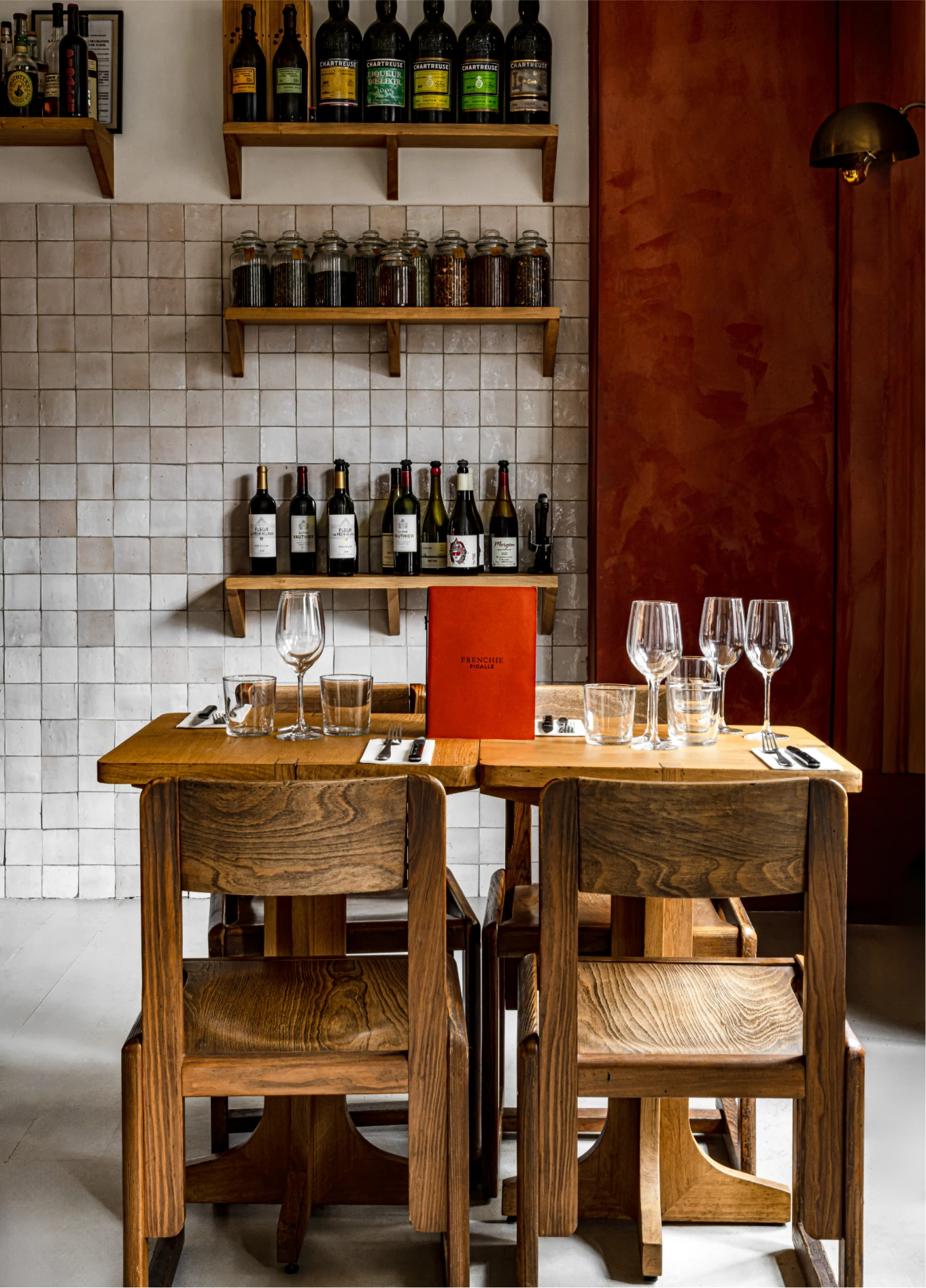 Dining room with wine bottle shelves and wooden tables at Frenchie restaurant, Grand Pigalle, Paris 9