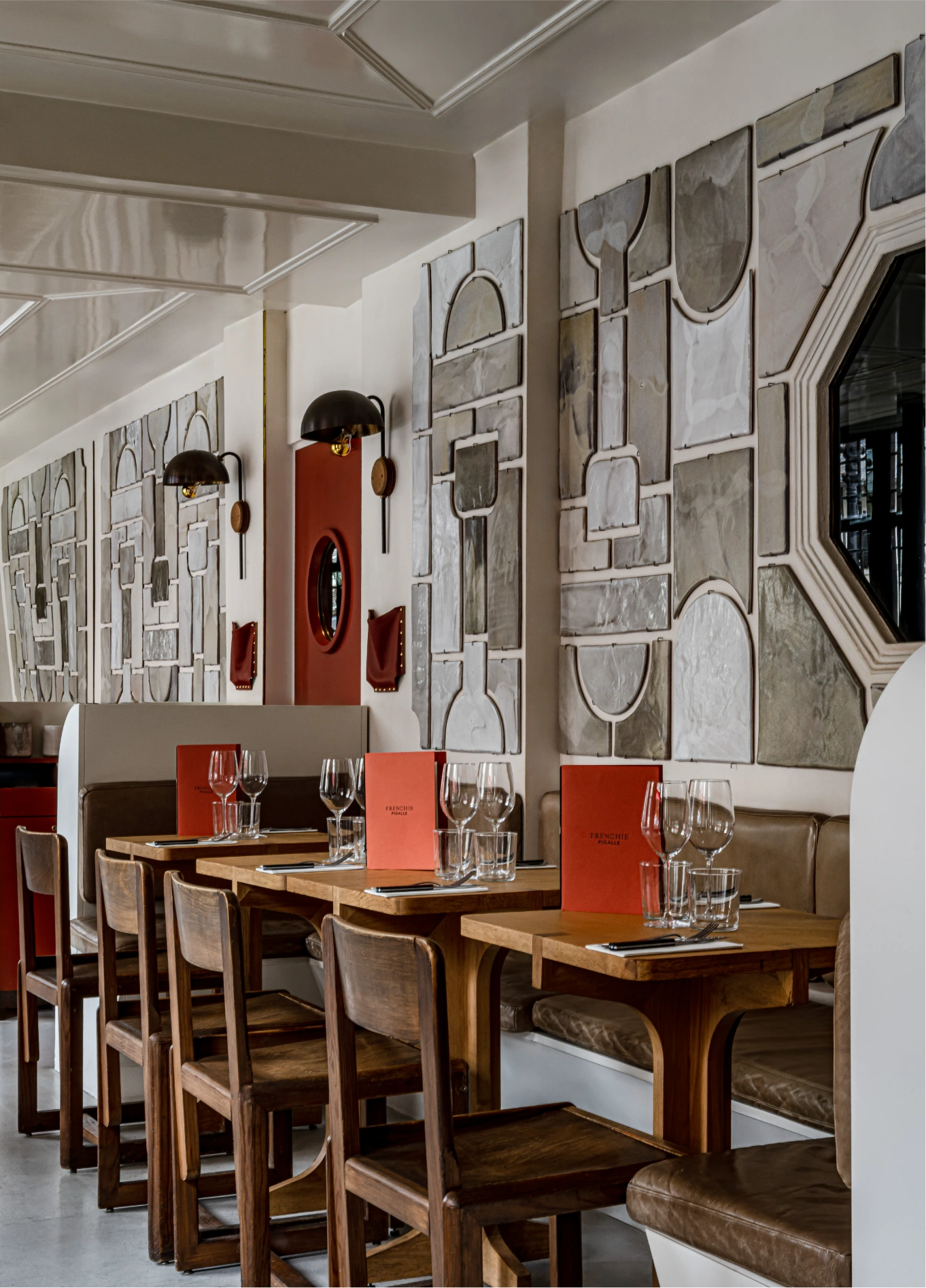Bright dining room with wooden chairs and large windows at Frenchie restaurant, Pigalle, Paris
