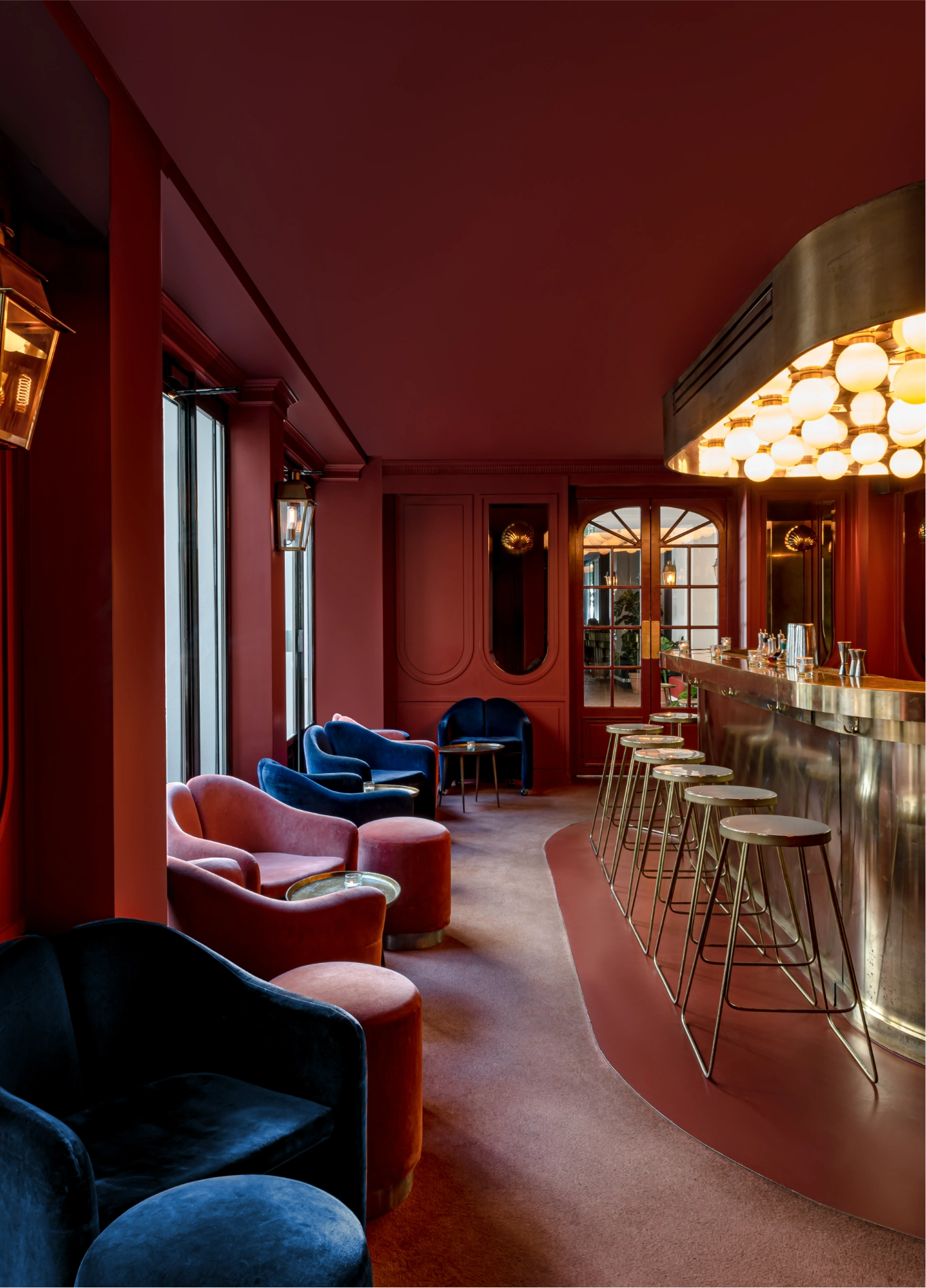 Red velvet lounge with dim lighting at The Shell cocktail bar, Grands Boulevards, Paris