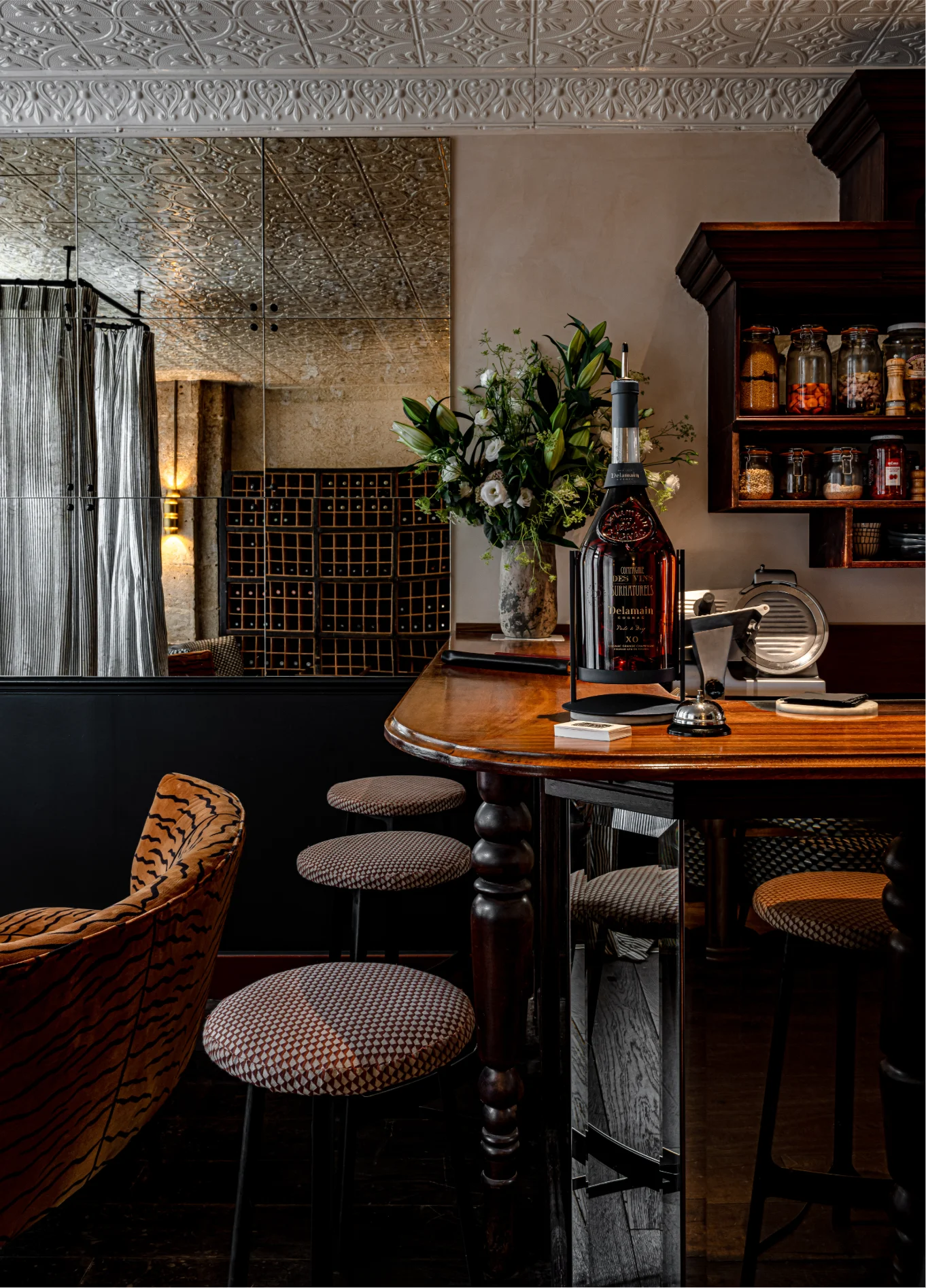 Interior view of La Compagnie St Germain showing a wooden bar counter, stools, and elegant decor.