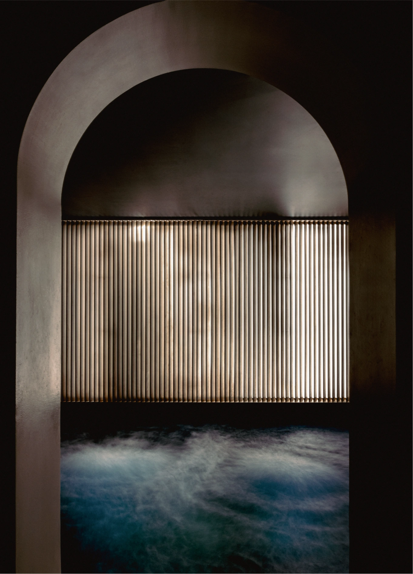 Arched indoor swimming pool with blue lighting at Spa by Experimental, Marais, Paris