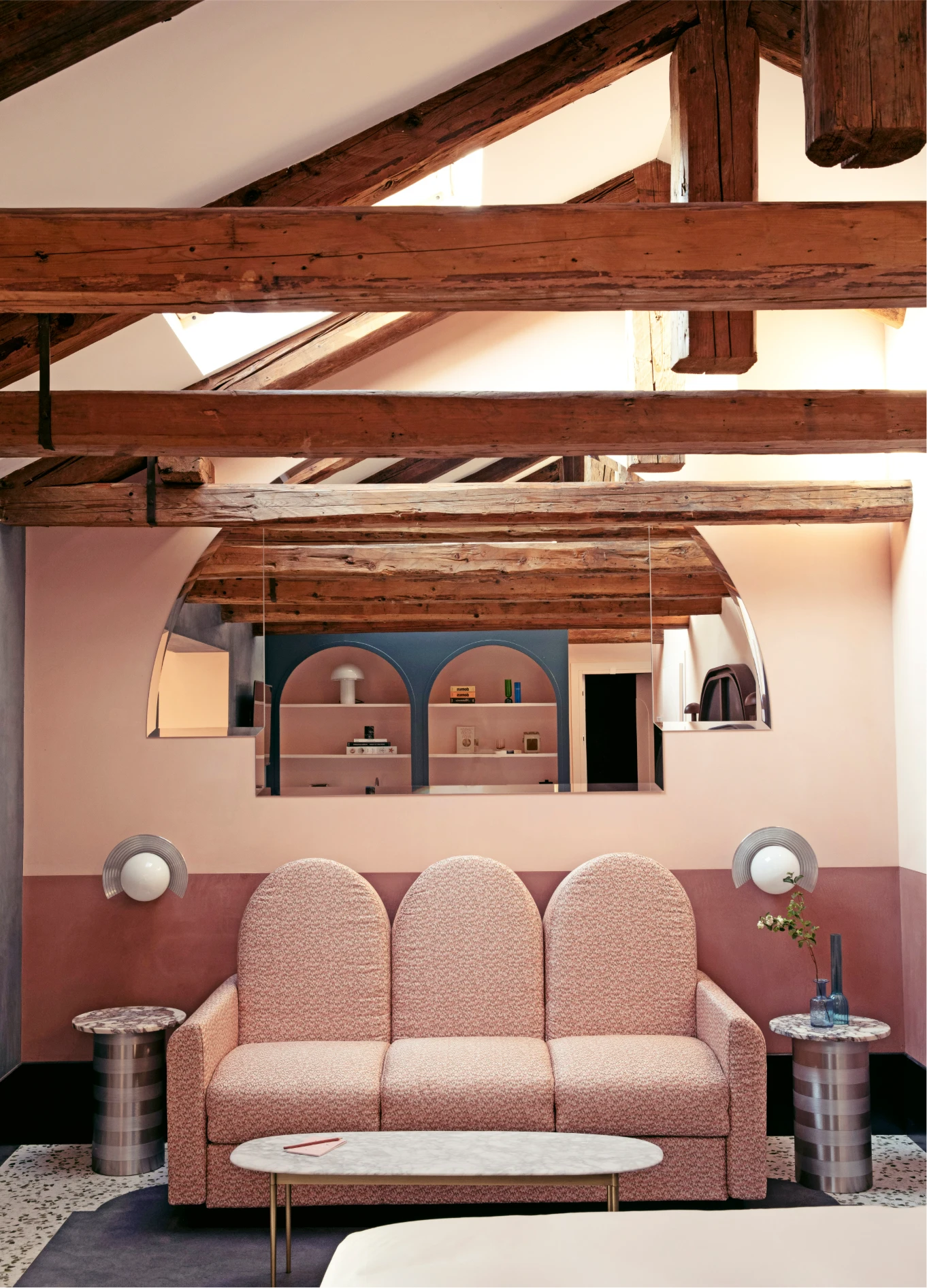 Living room with powder pink sofa and exposed beams at Il Palazzo Experimental, Venice