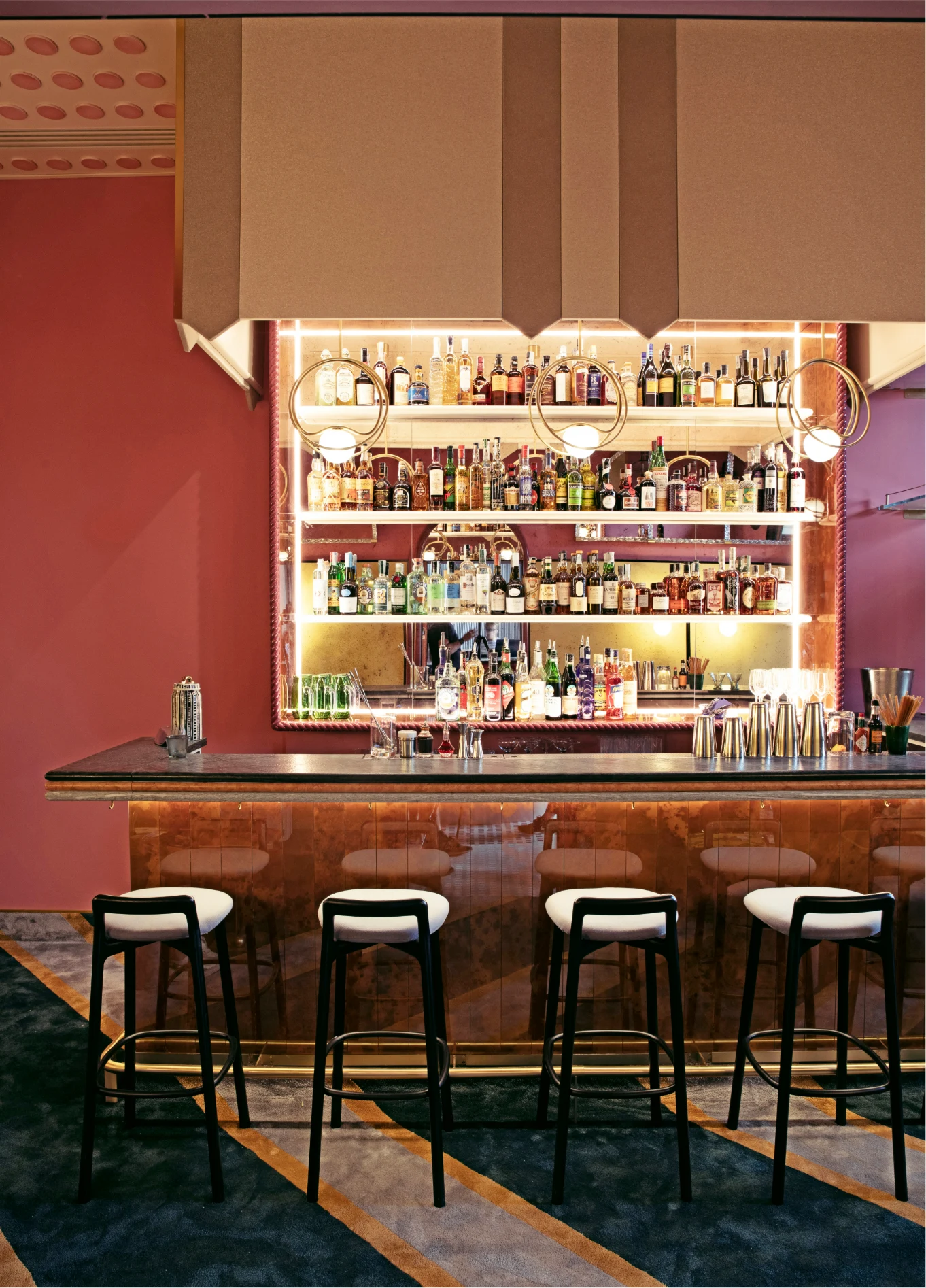 Bar with bottle shelves and red lighting at Experimental Cocktail Club, Venice