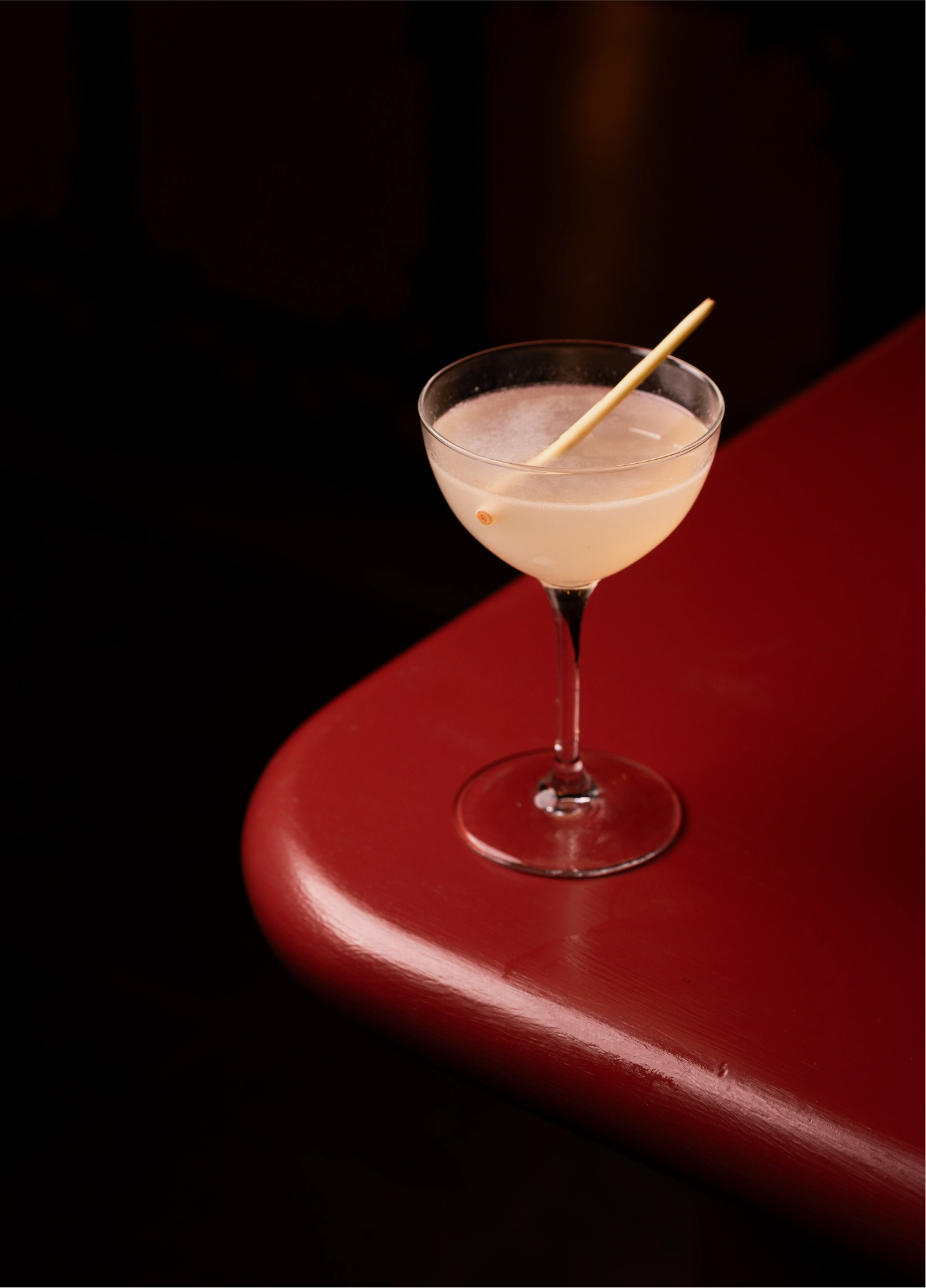 White cocktail coupe on red surface at Experimental Cocktail Club, Venice