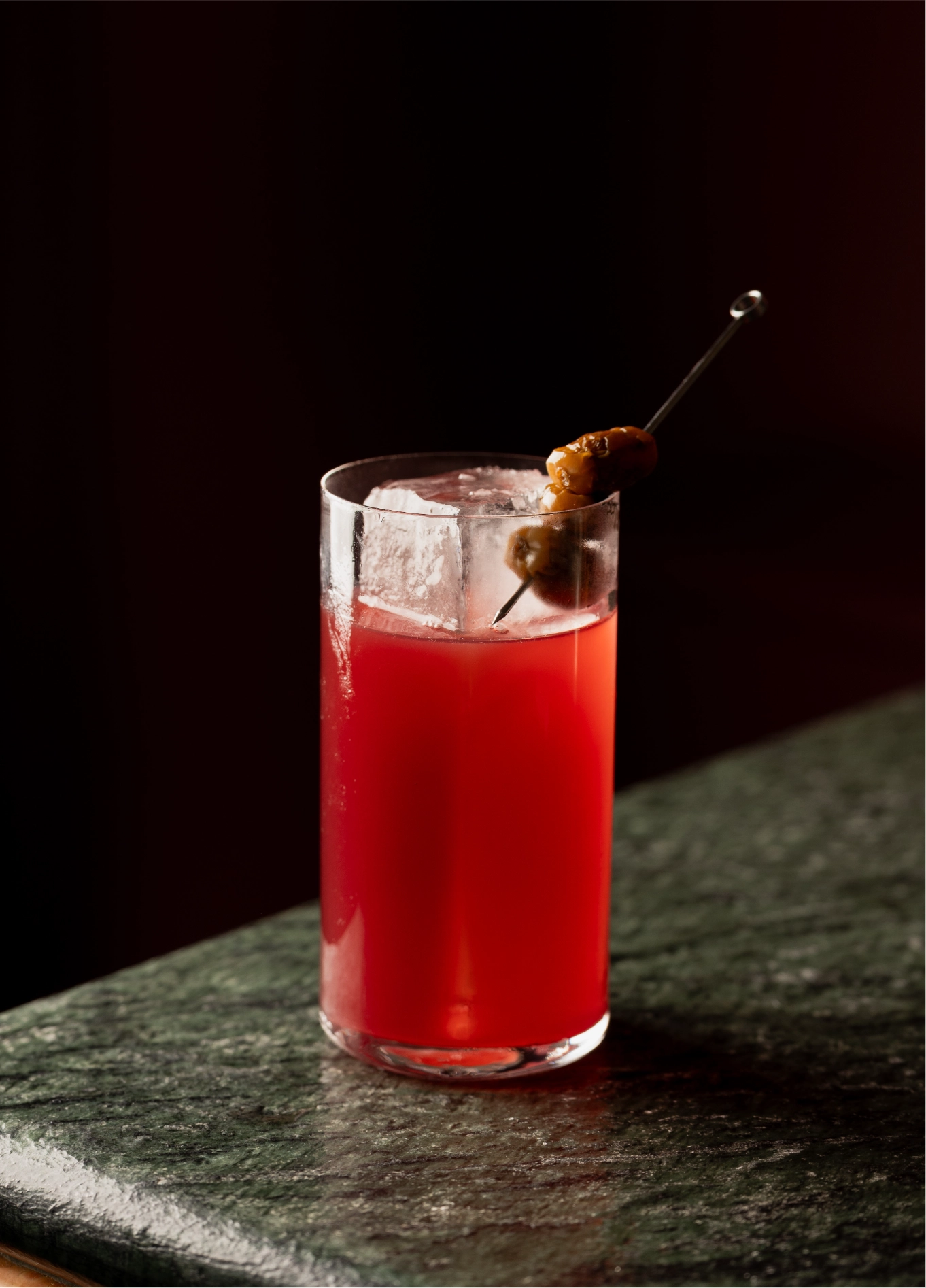 Red long drink cocktail on dark table at Experimental Cocktail Club, Venice