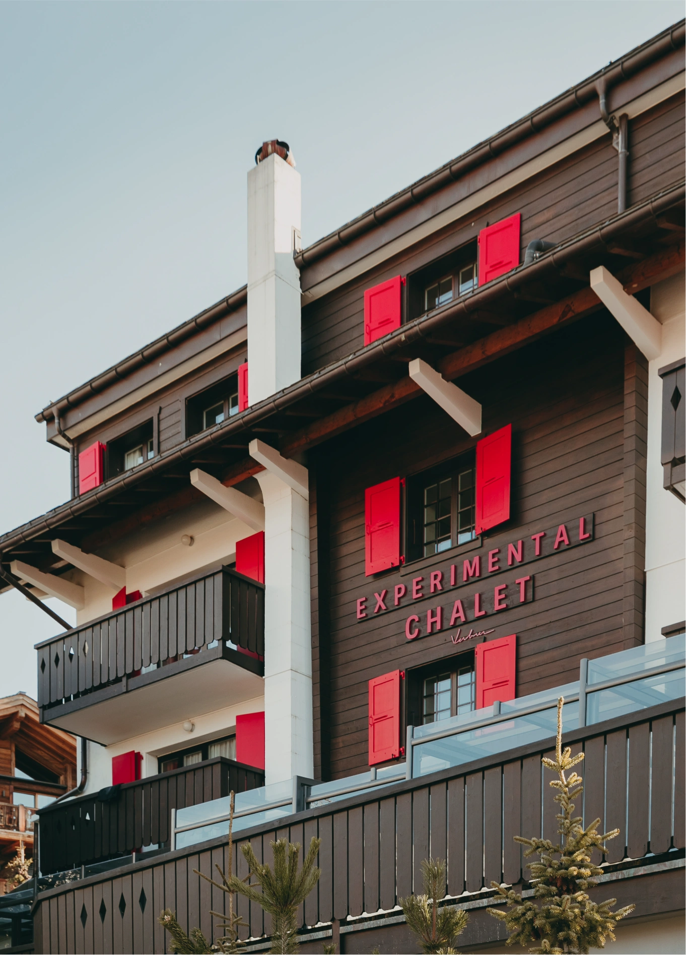 Exterior facade of Experimental Chalet with red shutters, Verbier, Swiss Alps