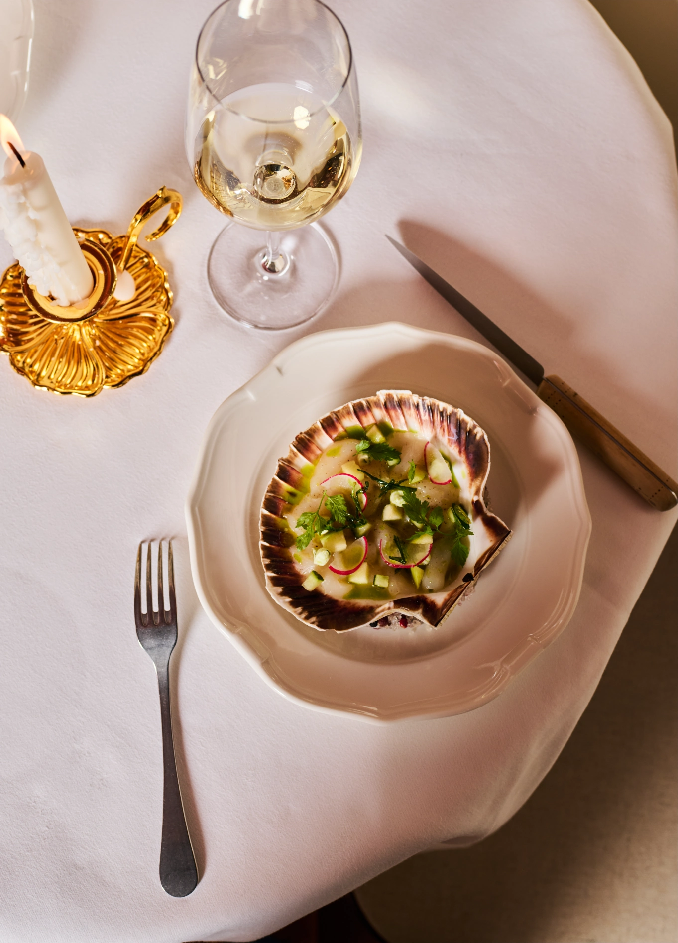 Gourmet dish with white wine glass at St Bernard fine dining restaurant, Verbier
