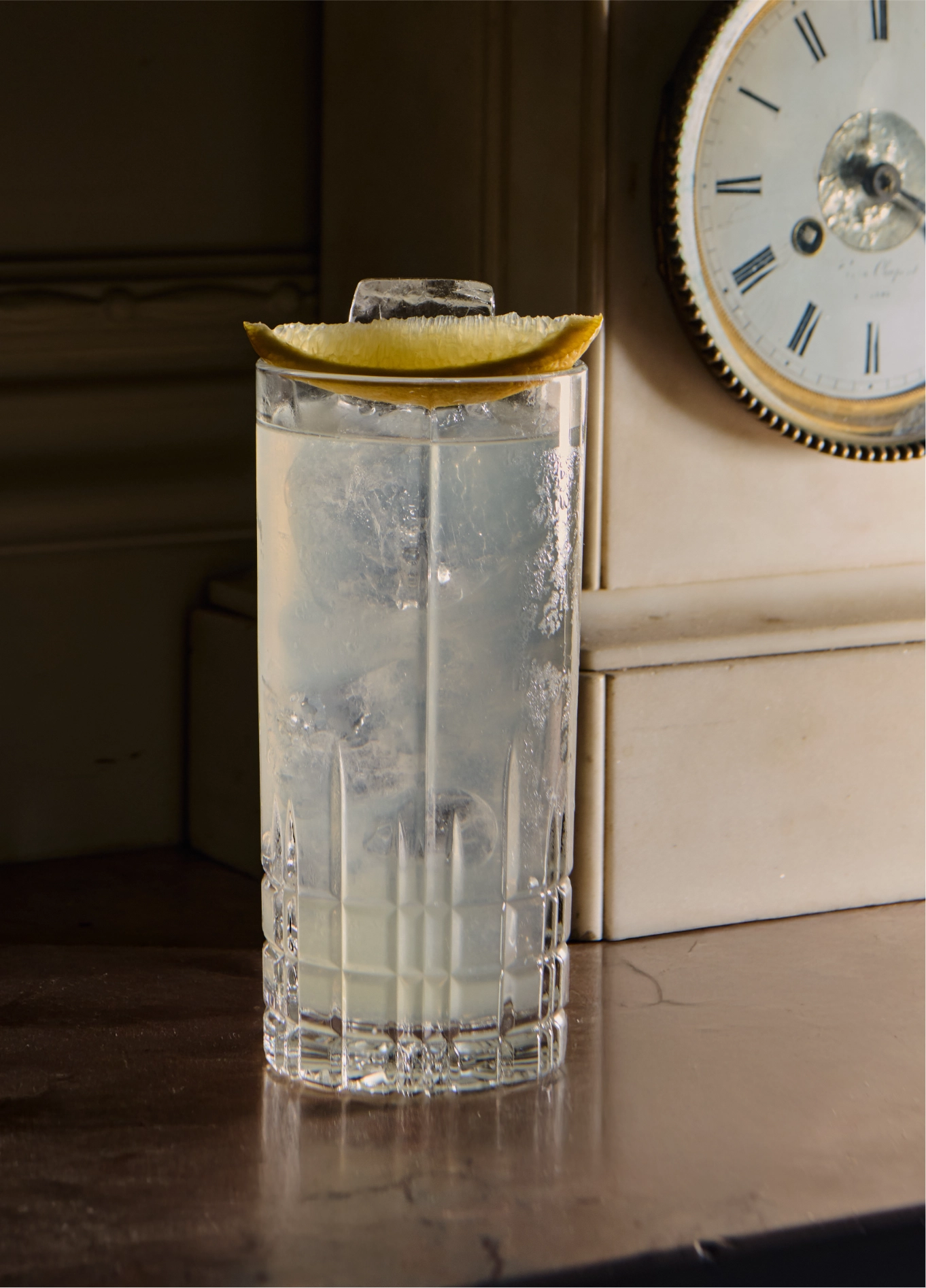 Long cocktail glass in front of antique clock at Experimental Cocktail Club, Verbier