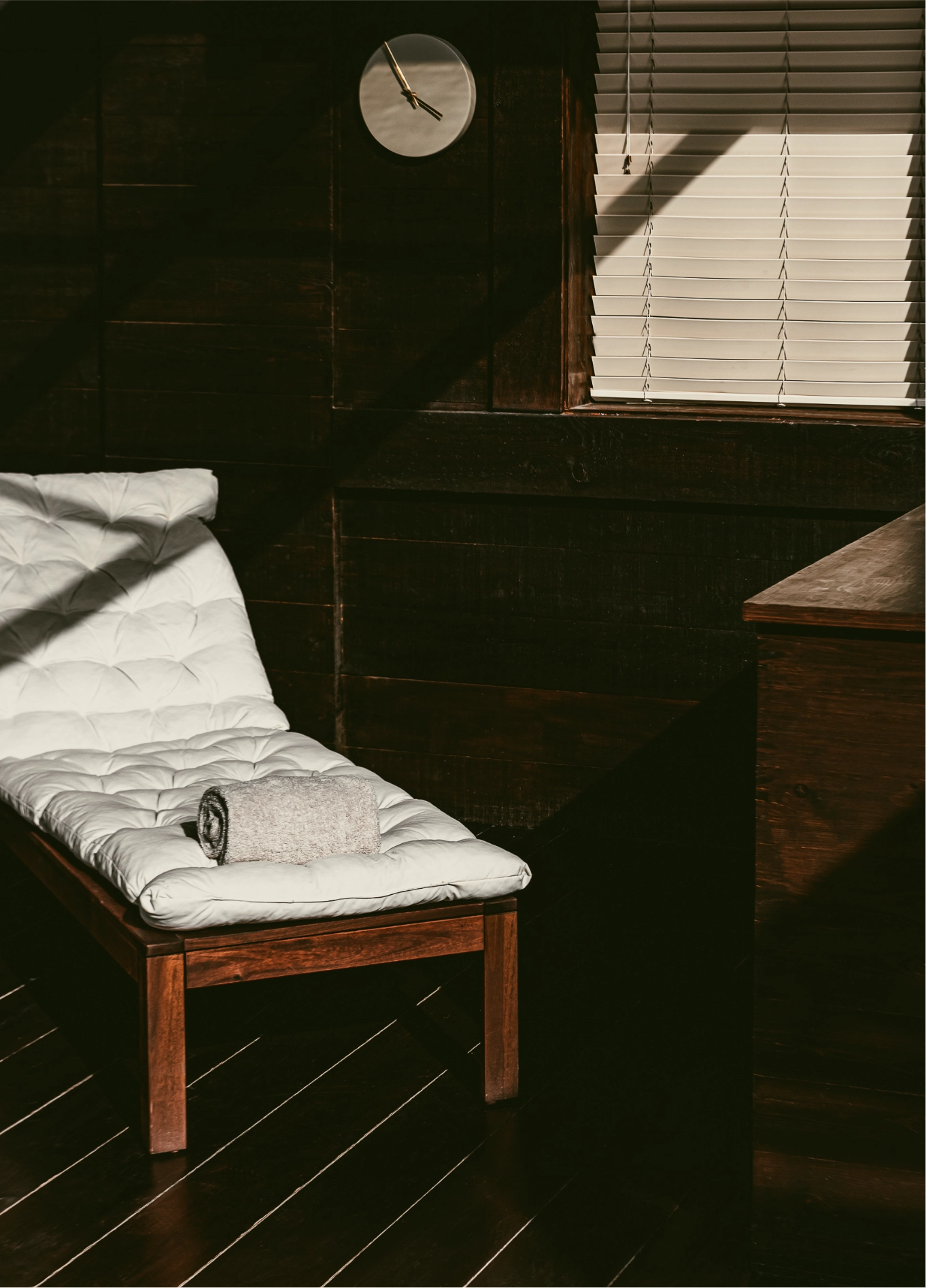 A white lounge chair in a room with dark walls and a cozy atmosphere at the Experimental Chalet Verbier hotel.