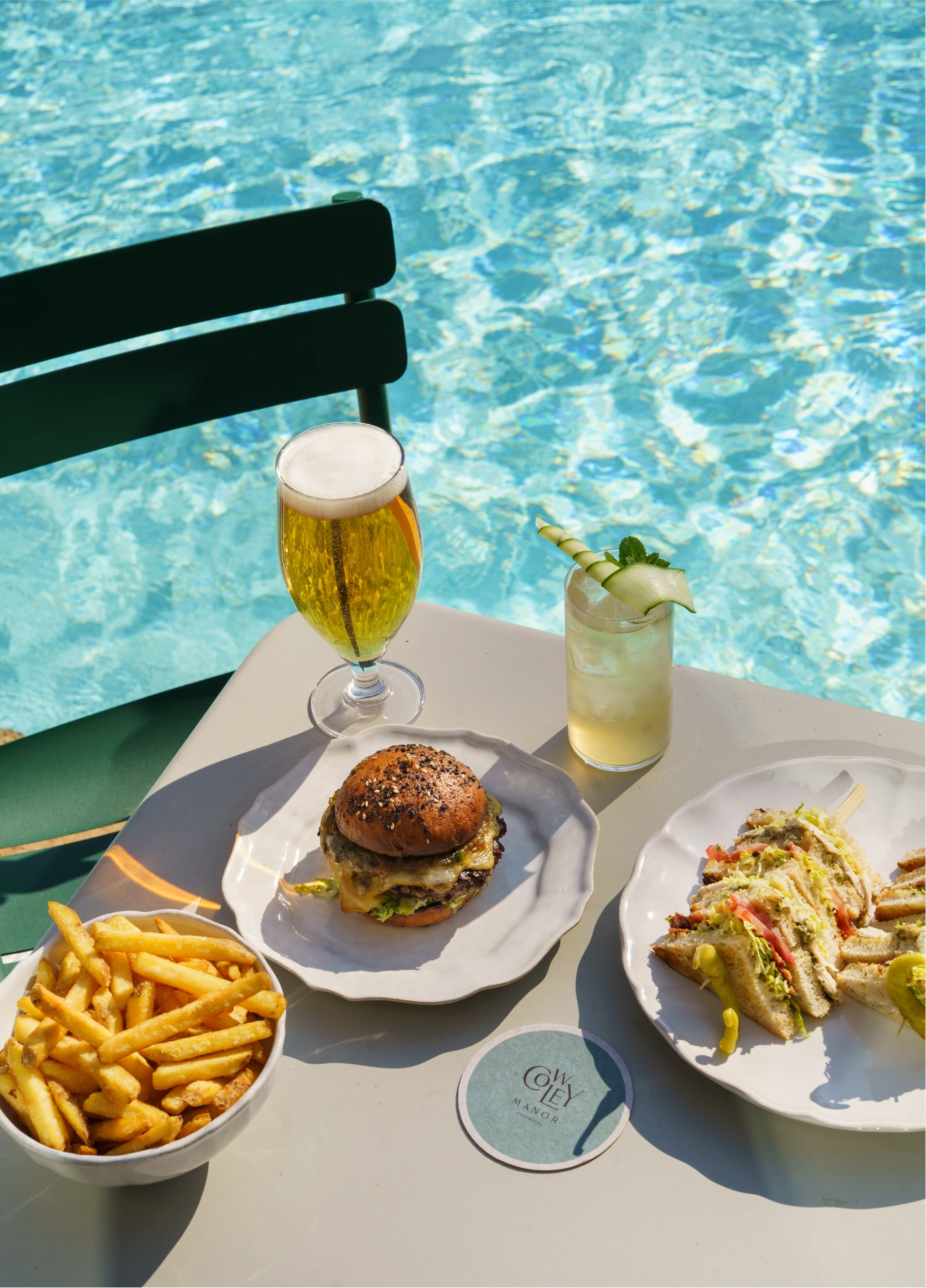 Burger and drinks by the swimming pool at Cowley Manor pool bar, Cotswolds