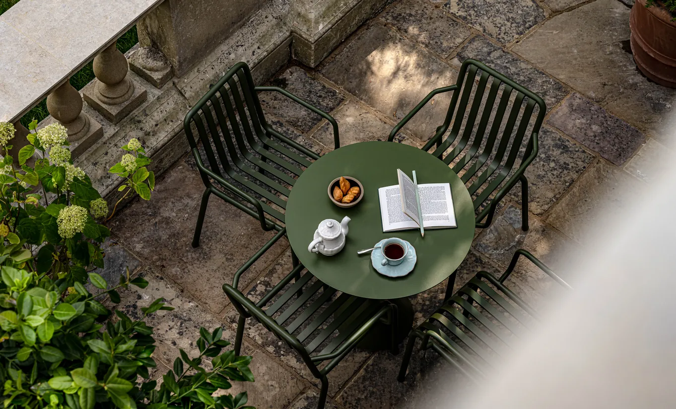 Aerial view of a private stone terrace with garden furniture surrounded by lush greenery in the Grand Cowley Manor Suite at Cowley Manor Experimental, Cotswolds