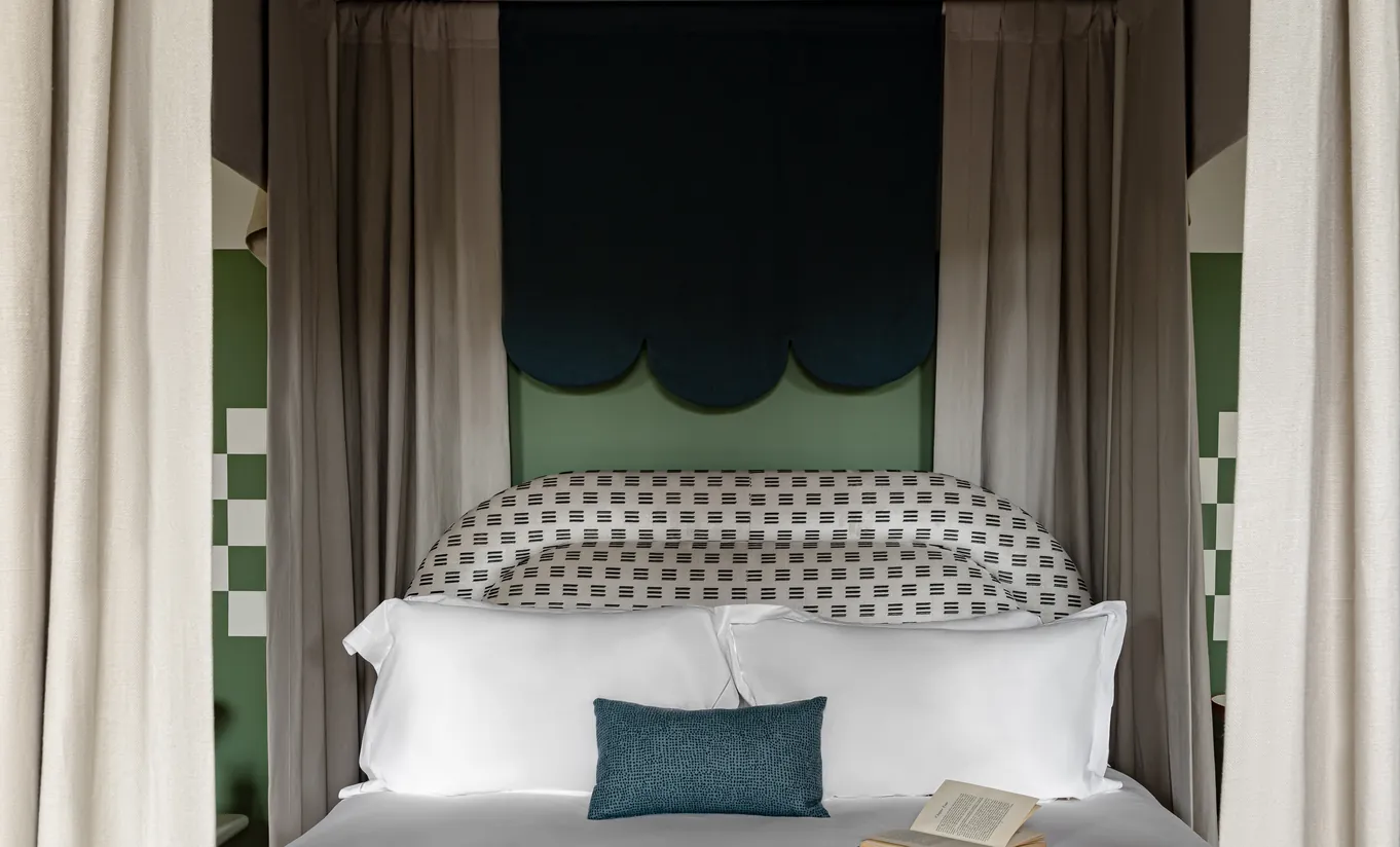 Bedroom with a four-poster bed, sage green canopy and patterned headboard in the St Mary Suite at Cowley Manor Experimental, a luxury hotel in the Cotswolds