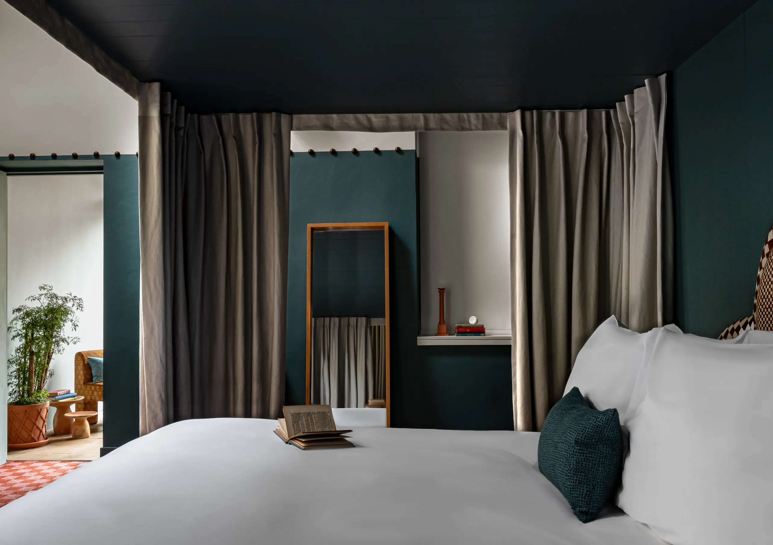 Bedroom with a white double bed, teal blue walls and terracotta pots by the window in the Alpaca's Room at Cowley Manor Experimental, Cotswolds