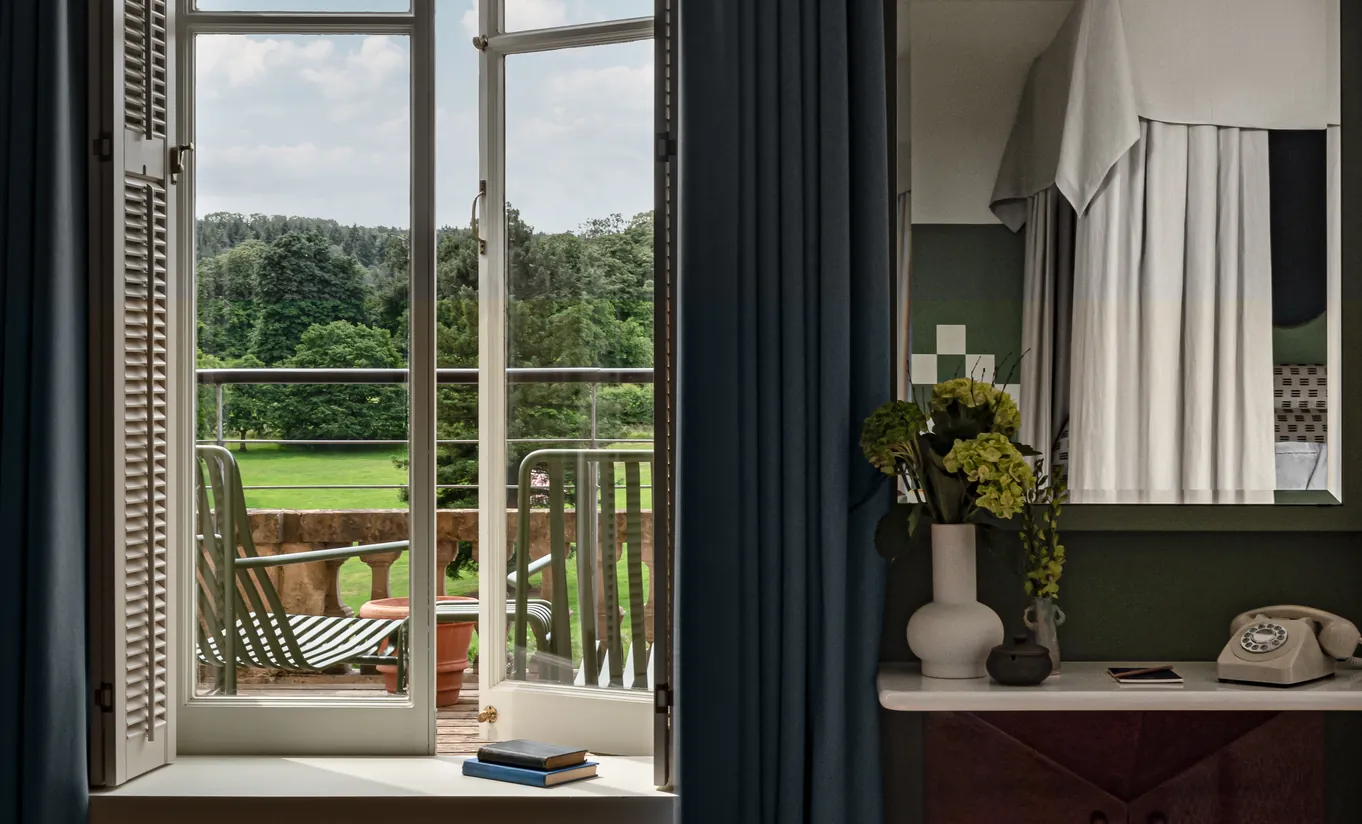 Balcony with open French doors overlooking the green Cotswolds countryside in the Cowley Manor Suite at Cowley Manor Experimental, perfect for a romantic getaway