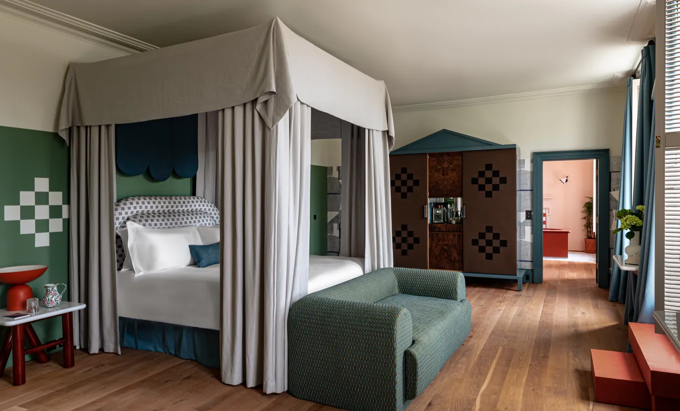 Bedroom with a four-poster bed and wooden floors in the Cowley Manor Suite at Cowley Manor Experimental, a luxury spa hotel in the Cotswolds
