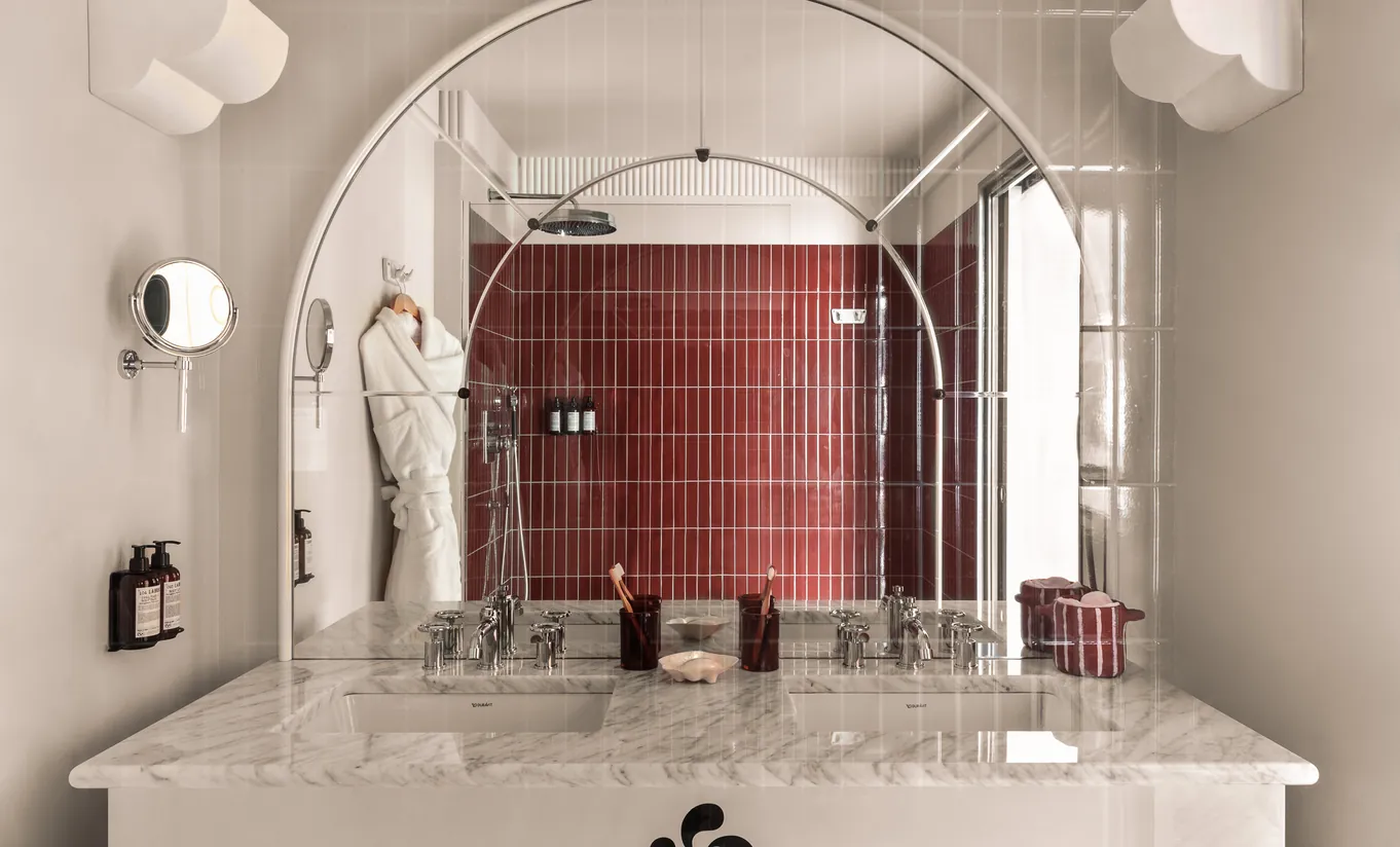 Regina Experimental bathroom with burgundy metro tiles, arched mirror and marble sink in Venice