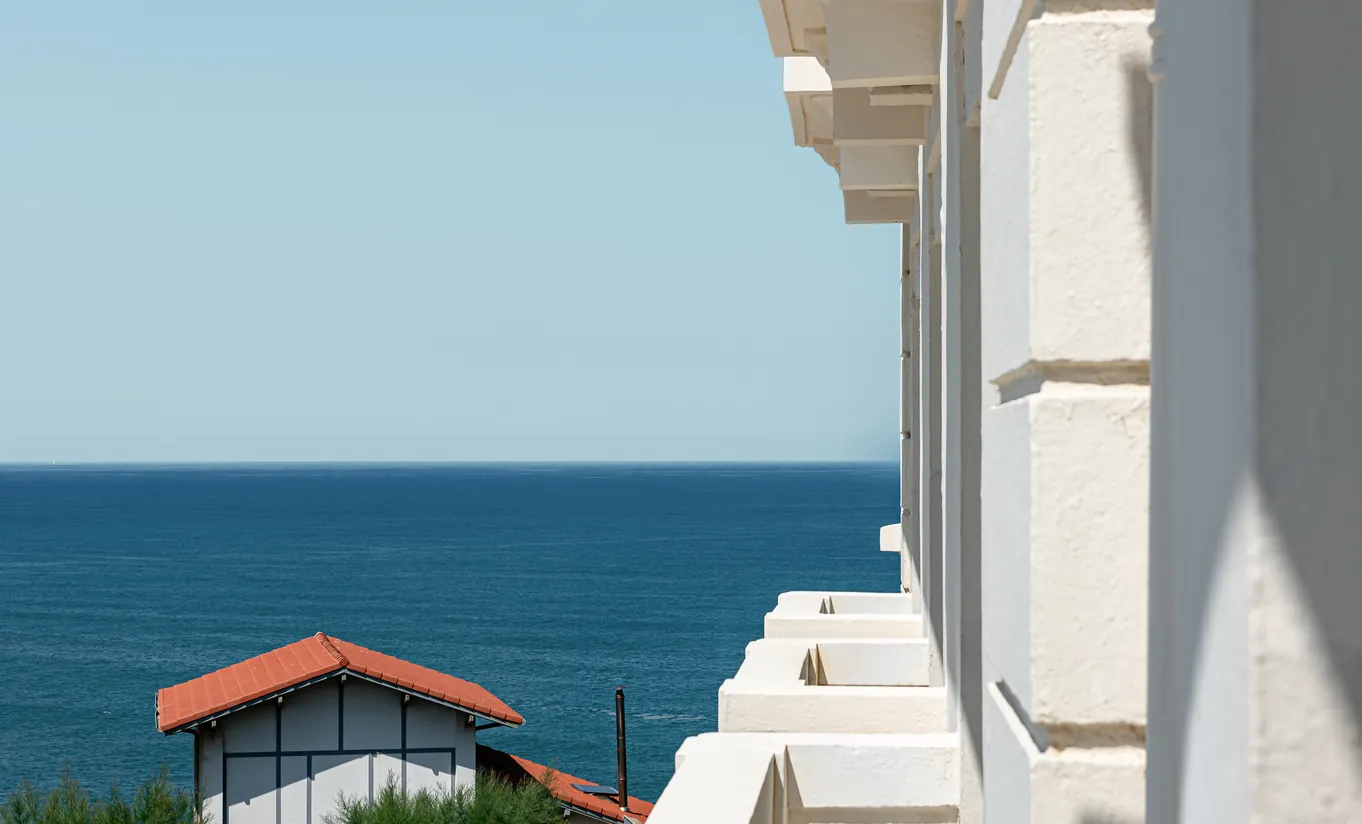 Regina Experimental Biarritz hotel exterior balcony detail with white ornate railing and sweeping view over the Atlantic Ocean coastline