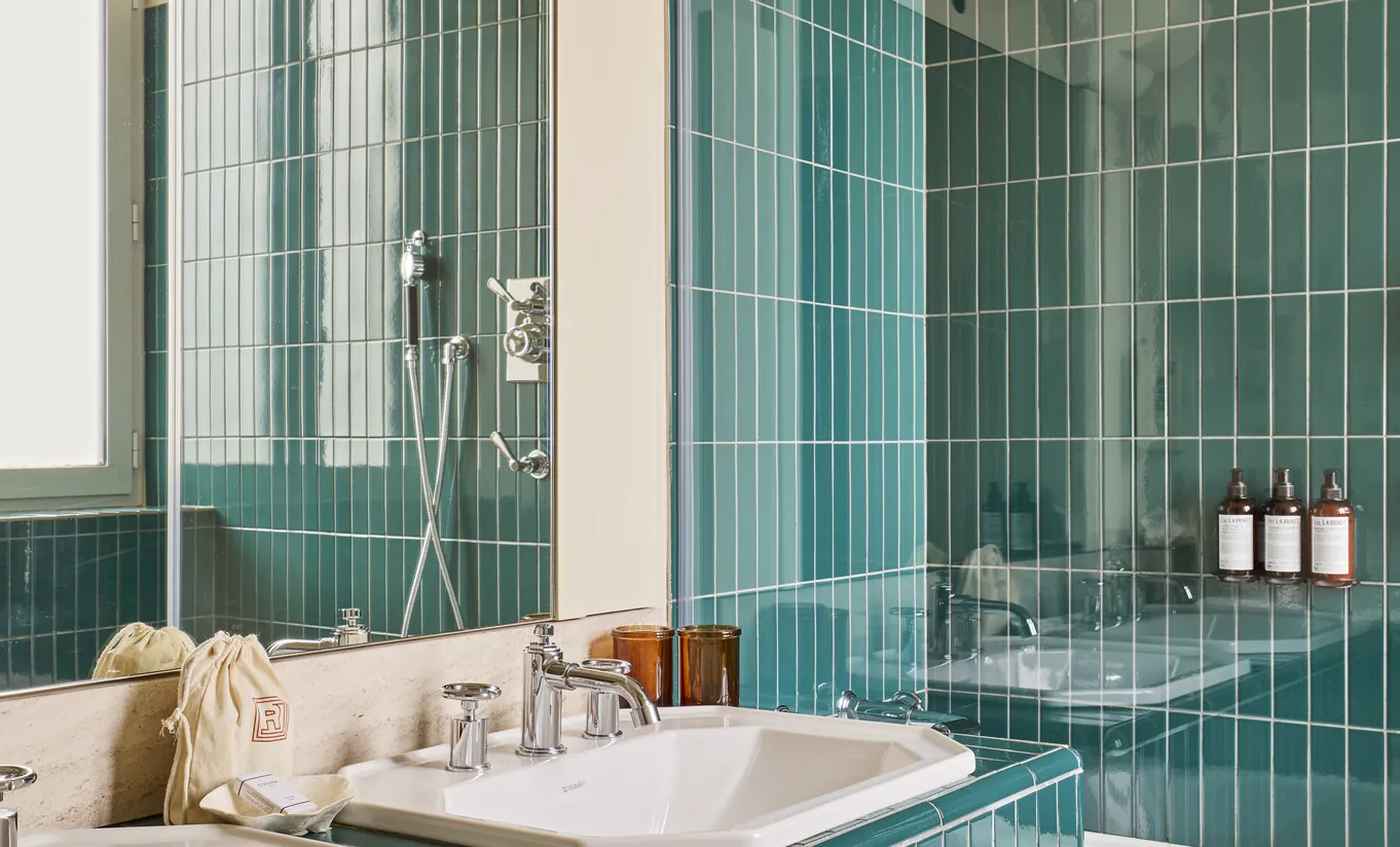 Regina Experimental hotel spa bathroom featuring green ceramic wall tiles and vintage chrome fixtures