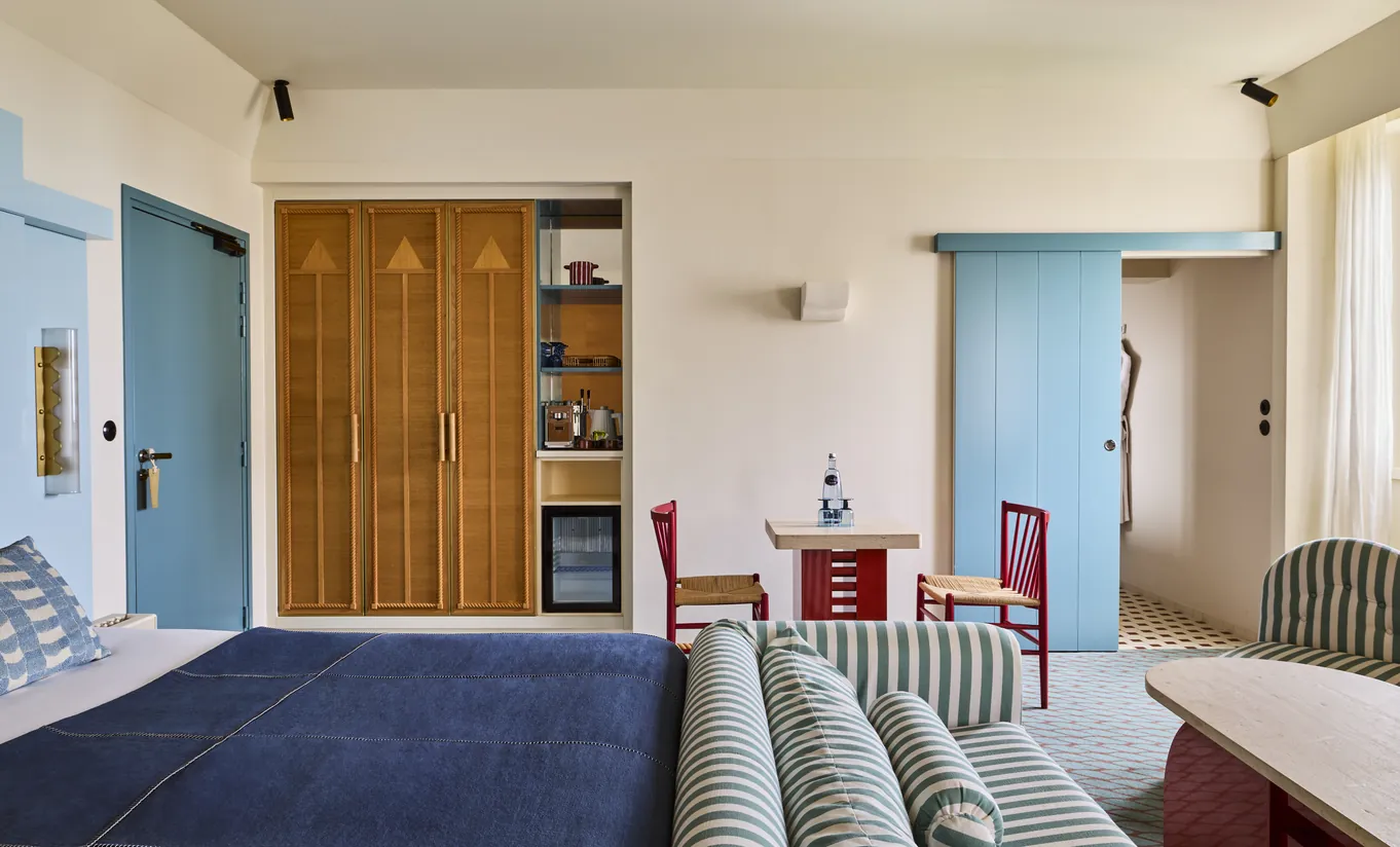 Regina Experimental hotel bedroom mid-century design with teal accents and warm wood wardrobe