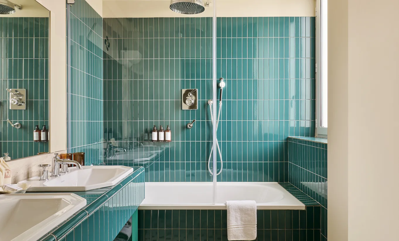 Regina Experimental hotel bathroom with floor-to-ceiling turquoise tiles and built-in bathtub