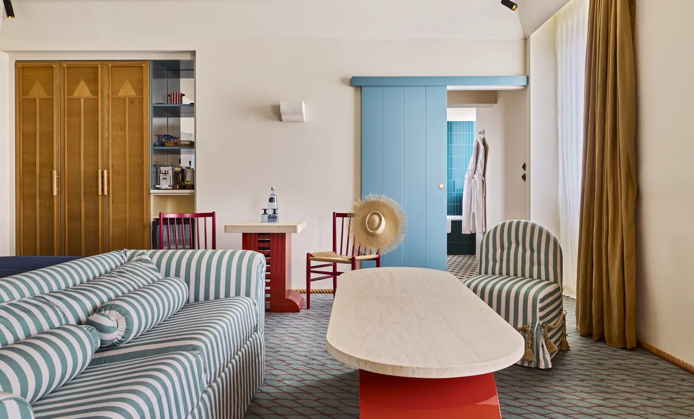 Experimental Group boutique hotel living room with vintage curved sofa and colorful eclectic decor