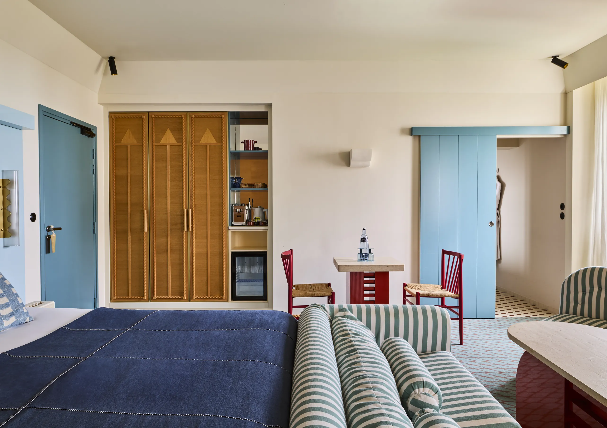 Regina Experimental hotel bedroom mid-century design with teal accents and warm wood wardrobe