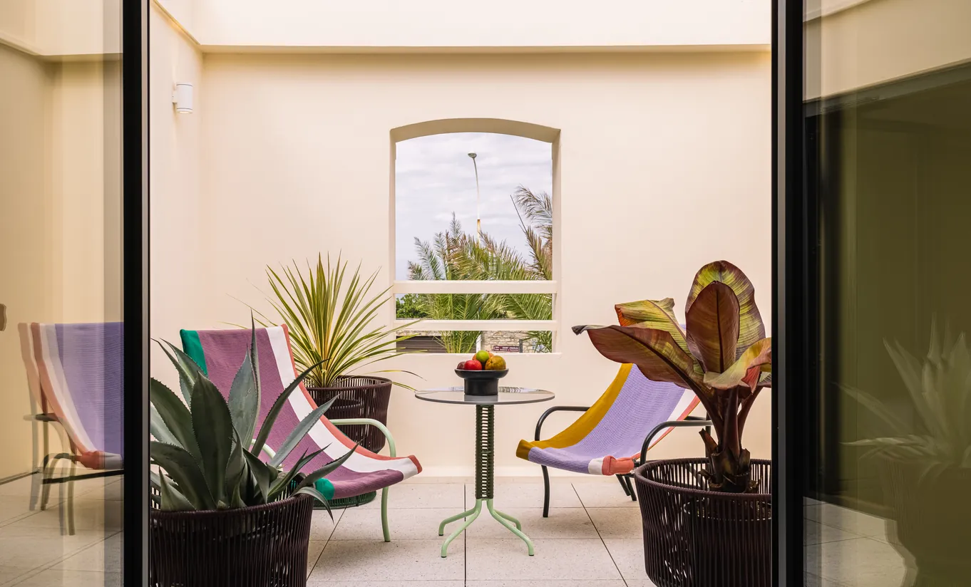 Experimental Group hotel serene lounge nook with two armchairs overlooking a green garden