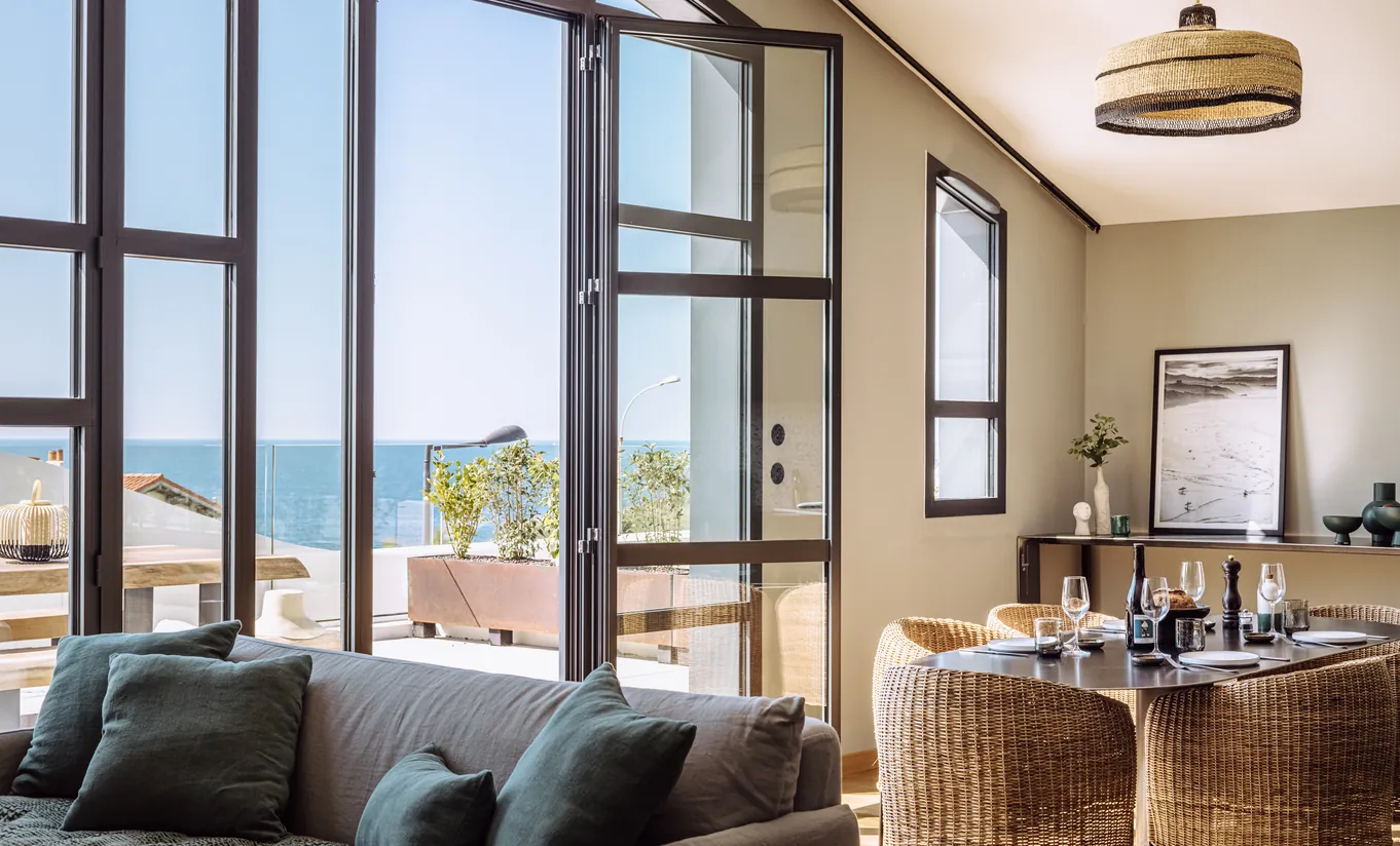 Experimental Group hotel bright suite with panoramic sea view, large bay windows and relaxed lounge seating