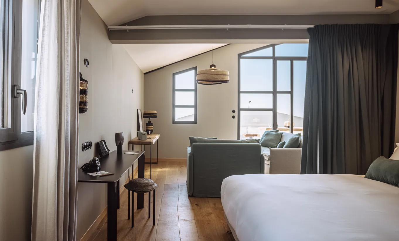 Experimental Group hotel charming bedroom with exposed stone arch, wooden desk and vintage-inspired decor