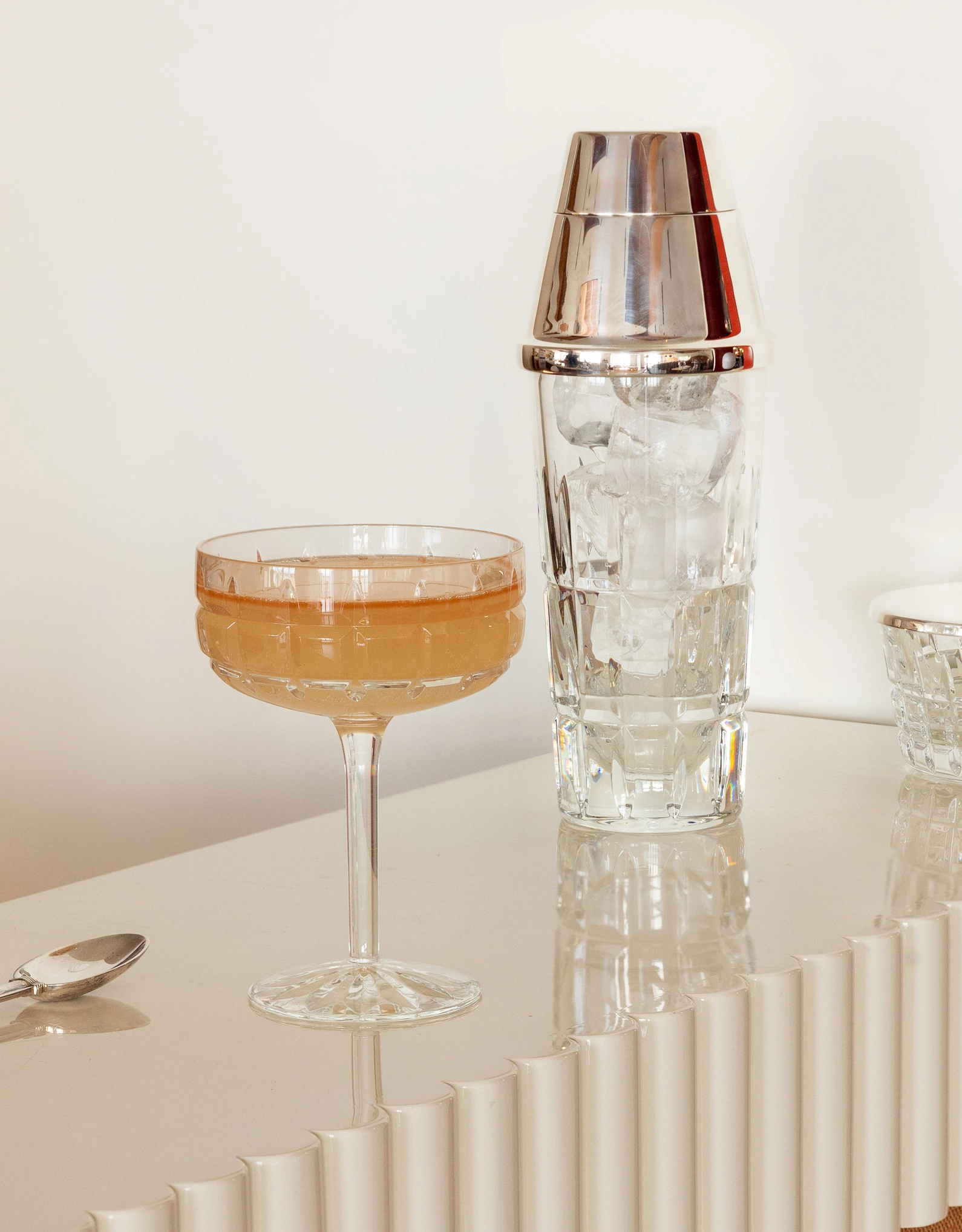 Professional bar tools and a prepared cocktail, recalling the mixology expertise at the heart of the Experimental Group.
