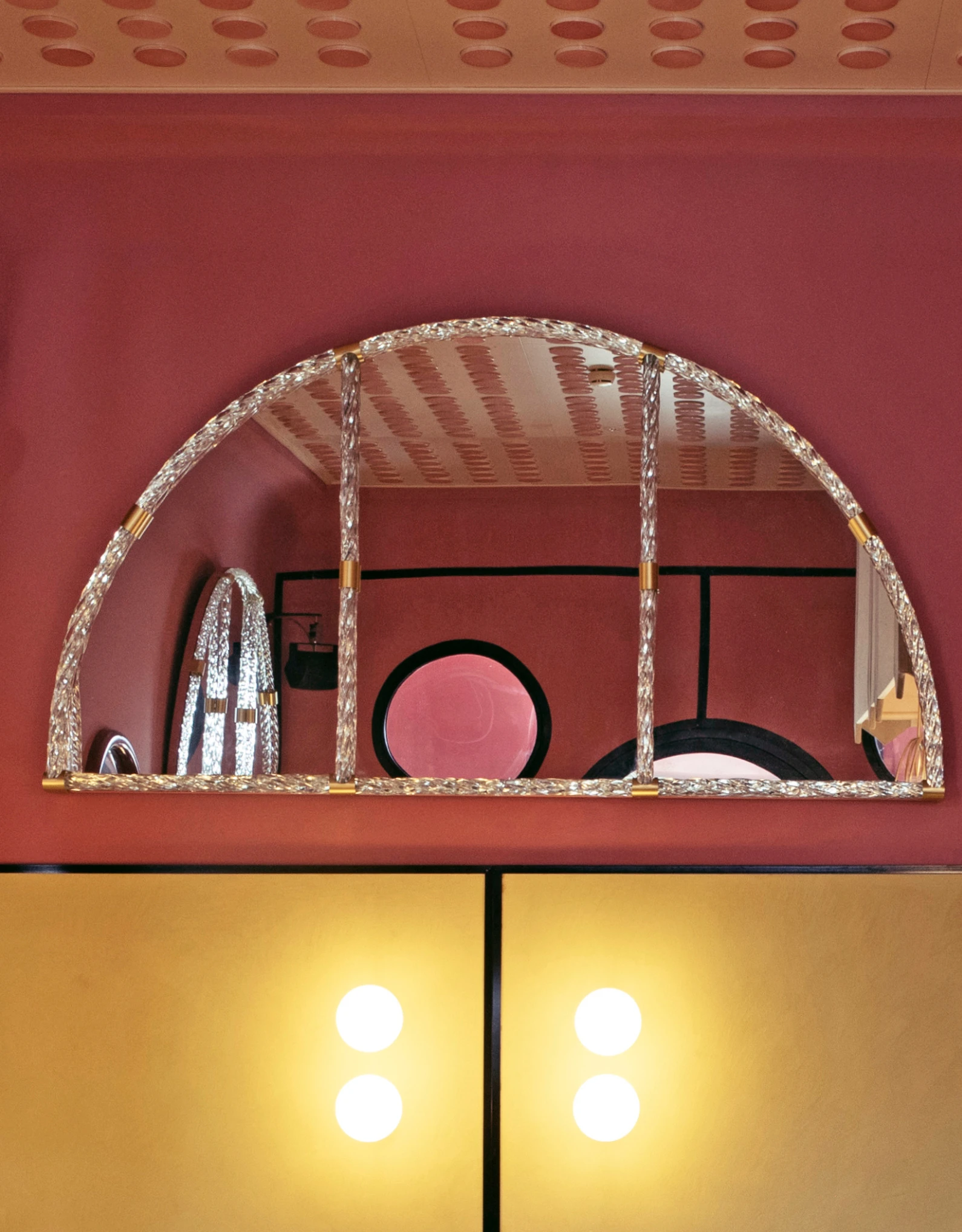 Decorative arched mirror in a room with warm tones, highlighting the creative elegance and refined design of the Experimental Group.