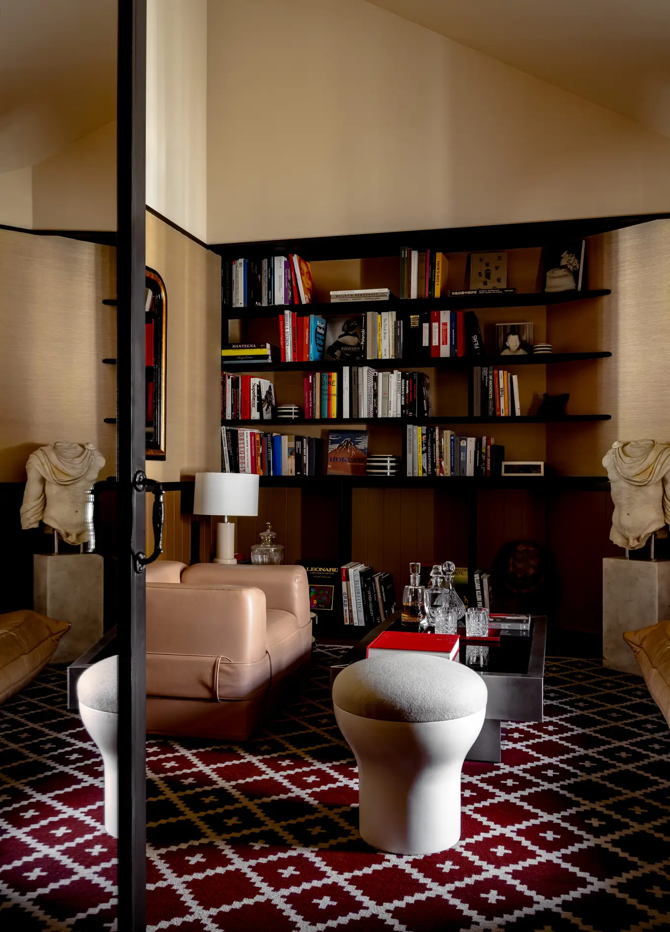 Bedroom with built-in bookshelf and patterned rug at Experimental Marais, Paris