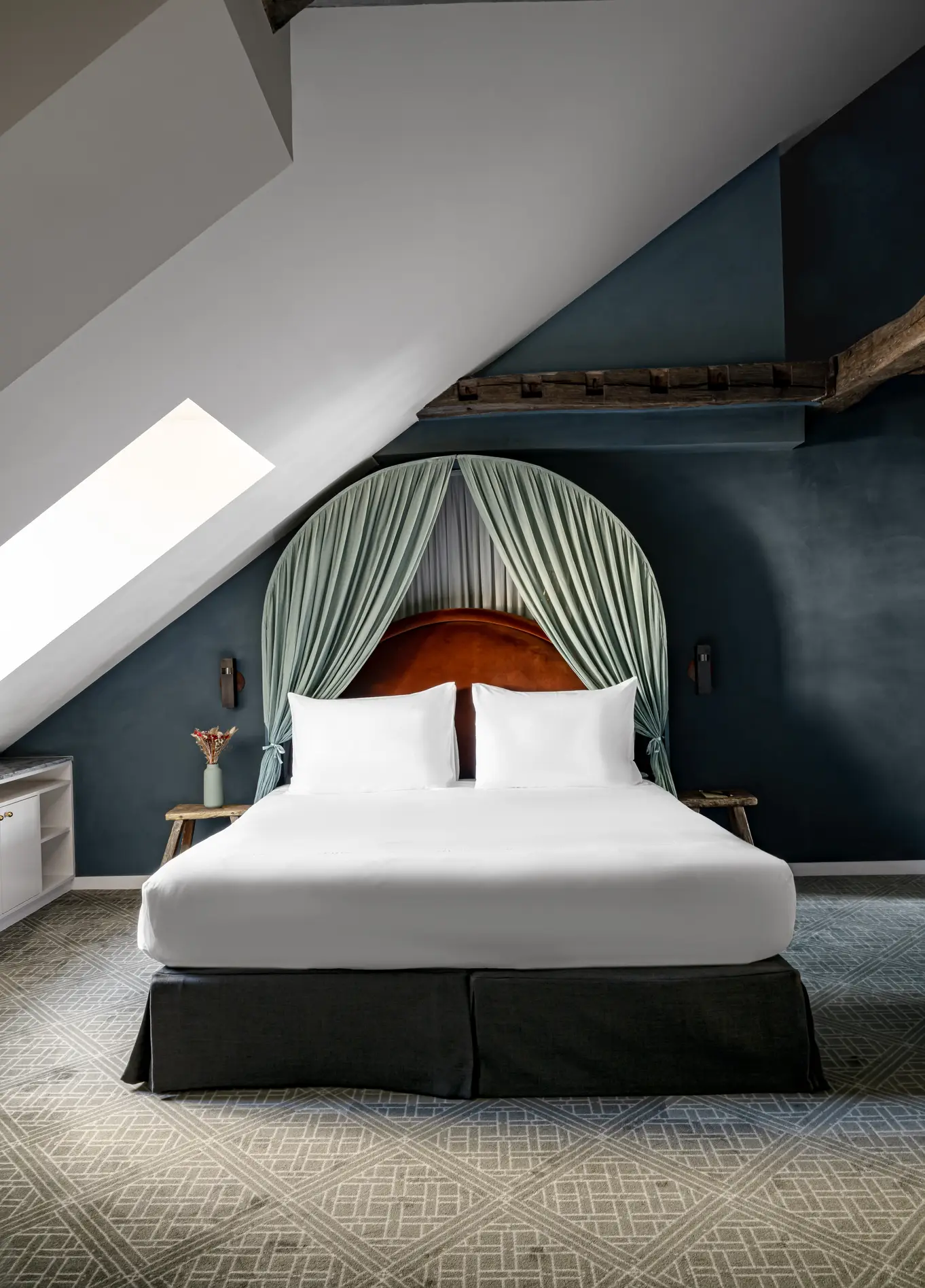 Attic bedroom with green tufted headboard and white bed at Grands Boulevards Experimental, Paris 2