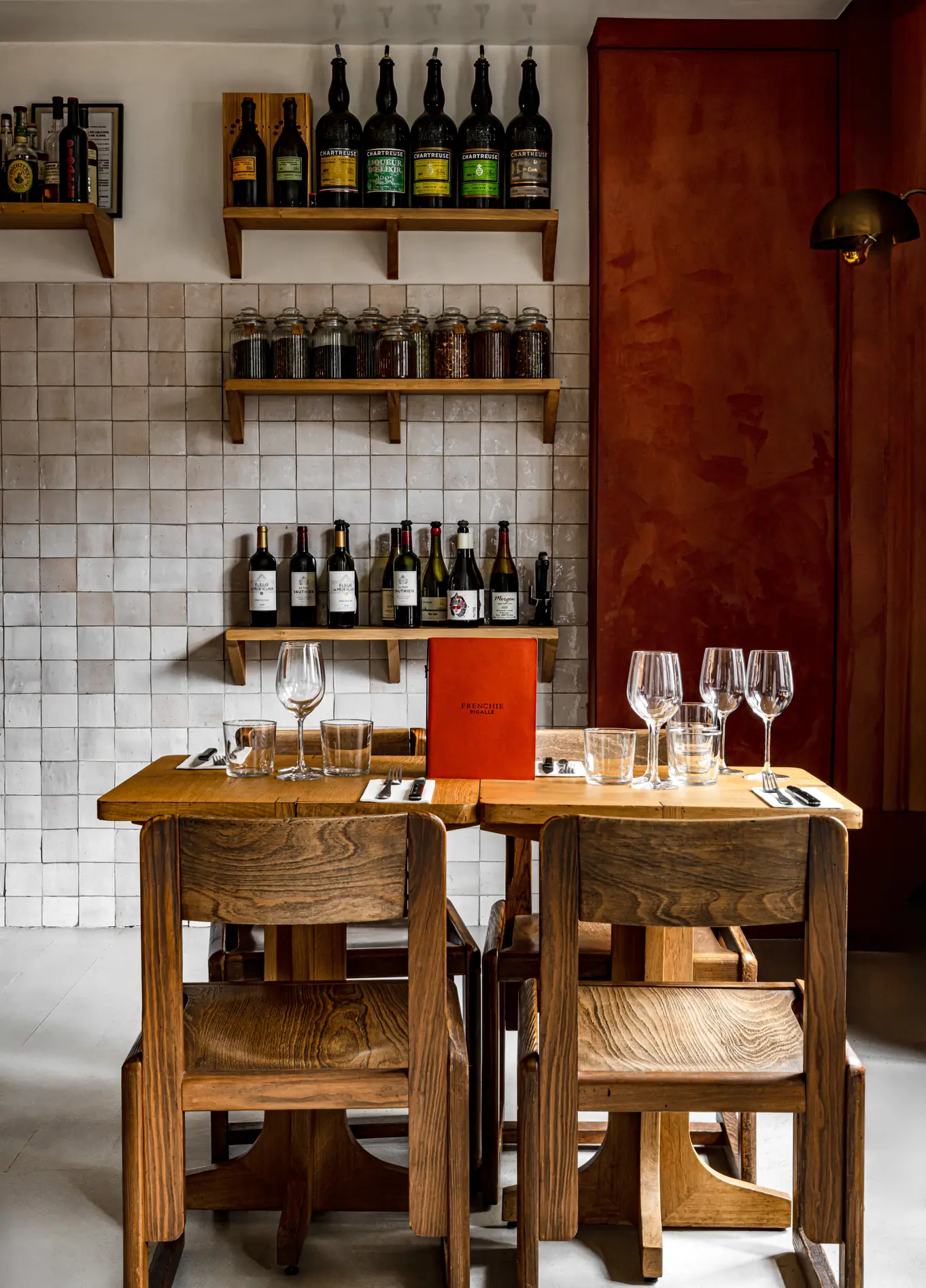 Dining room with wine bottle shelves and wooden tables at Frenchie restaurant, Grand Pigalle, Paris 9